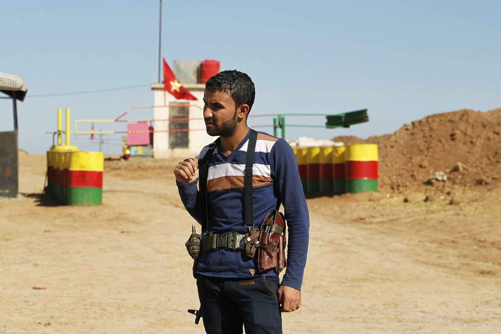 Un miembro de la milicia del Partido de la Unión Democrática (PYD) hace guardia junto a un puesto de control en la frontera sirio-iraquí