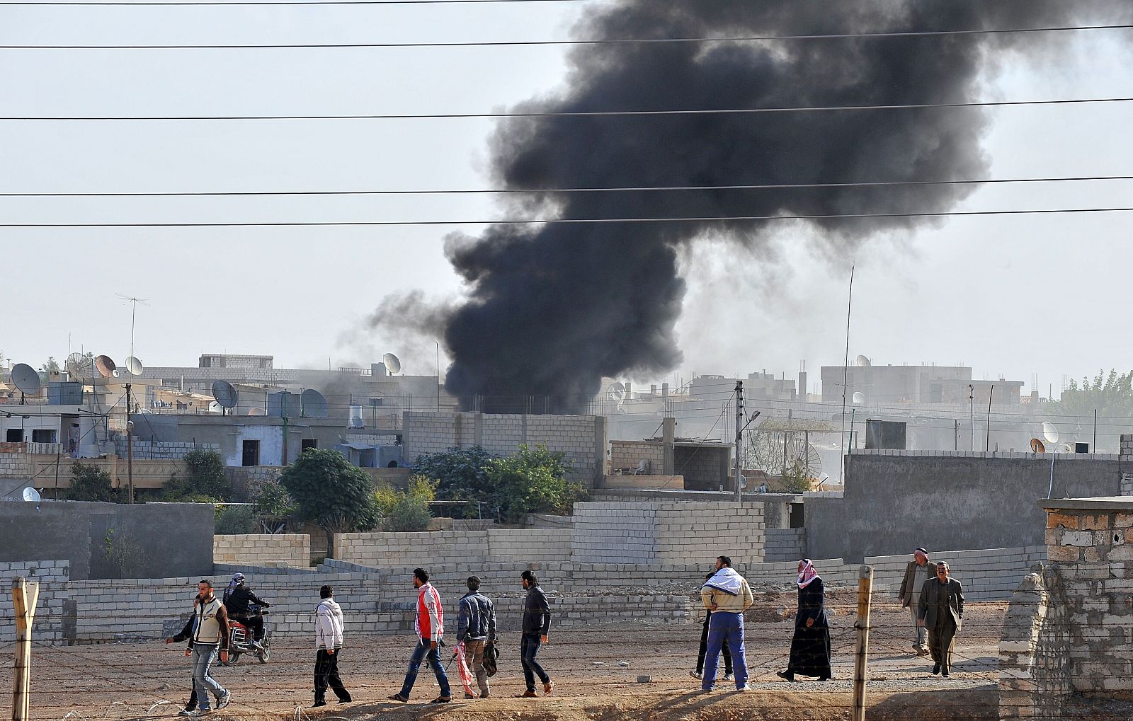 Fotografía, tomada desde la localidad turca de Ceylanpinar, que muestra humo sobre el pueblo sirio de Ras al Ain