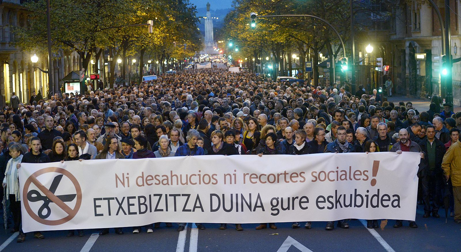 Thousands of demonstrators march behind a banner reading "Not Evictions, Nor Social Cuts. Housing Is A Right" during a protest against evictions in Bilbao