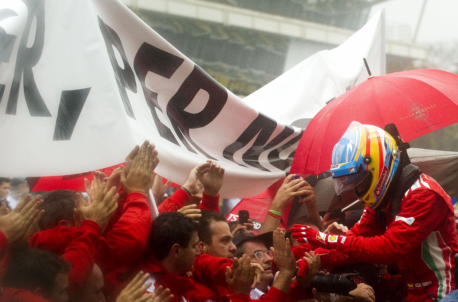 Fernando Alonso recibe el consuelo de los mecánicos de Ferrari tras el GP de Brasil