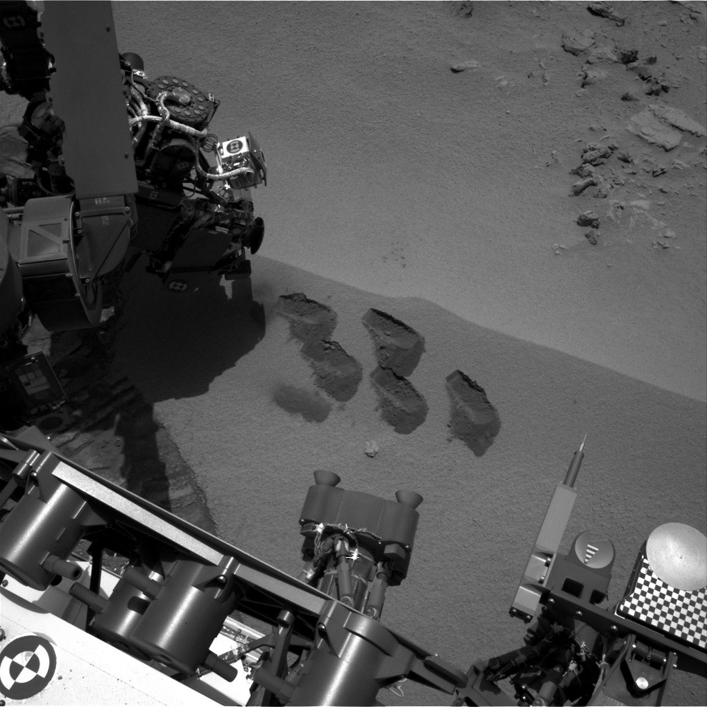 Imagen de la NASA donde se ven cinco marcas en la superficie marciana, tomada por la pala del brazo robótico del Curiosity.