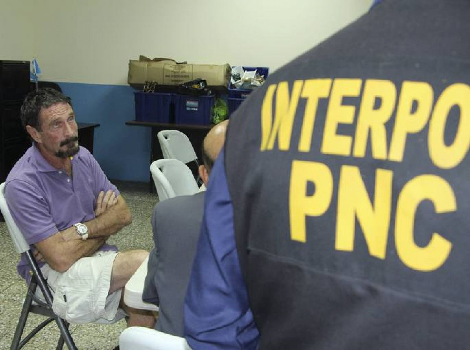John McAfee sentado junto a un agente de la INTERPOL en Guatemala, el 5 de diciembre