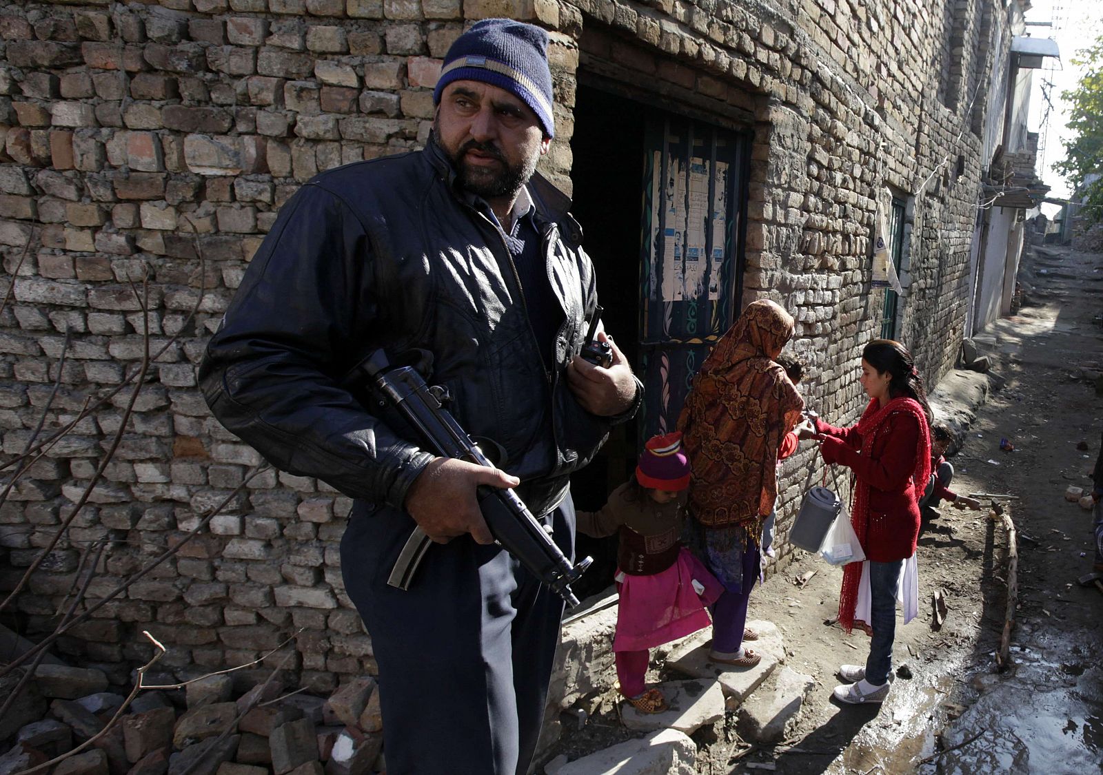 Un policía escolta a una sanitaria que vacuna contra la polio en un barrio de Islamabad este jueves.