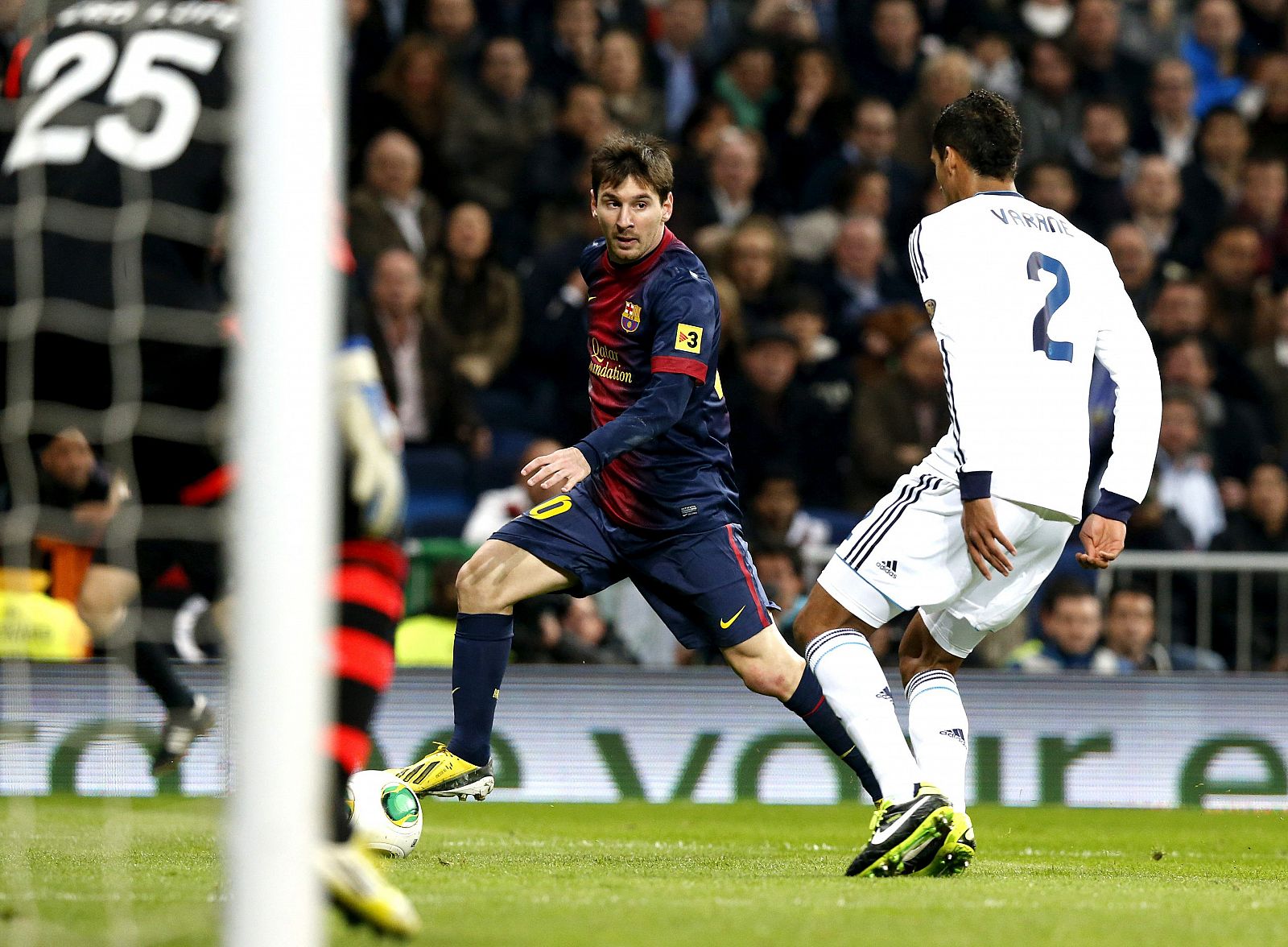 El delantero argentino del F.C. Barcelona Lionel Messi con el balón ante el defensa francés del Real Madrid Raphael Varane.