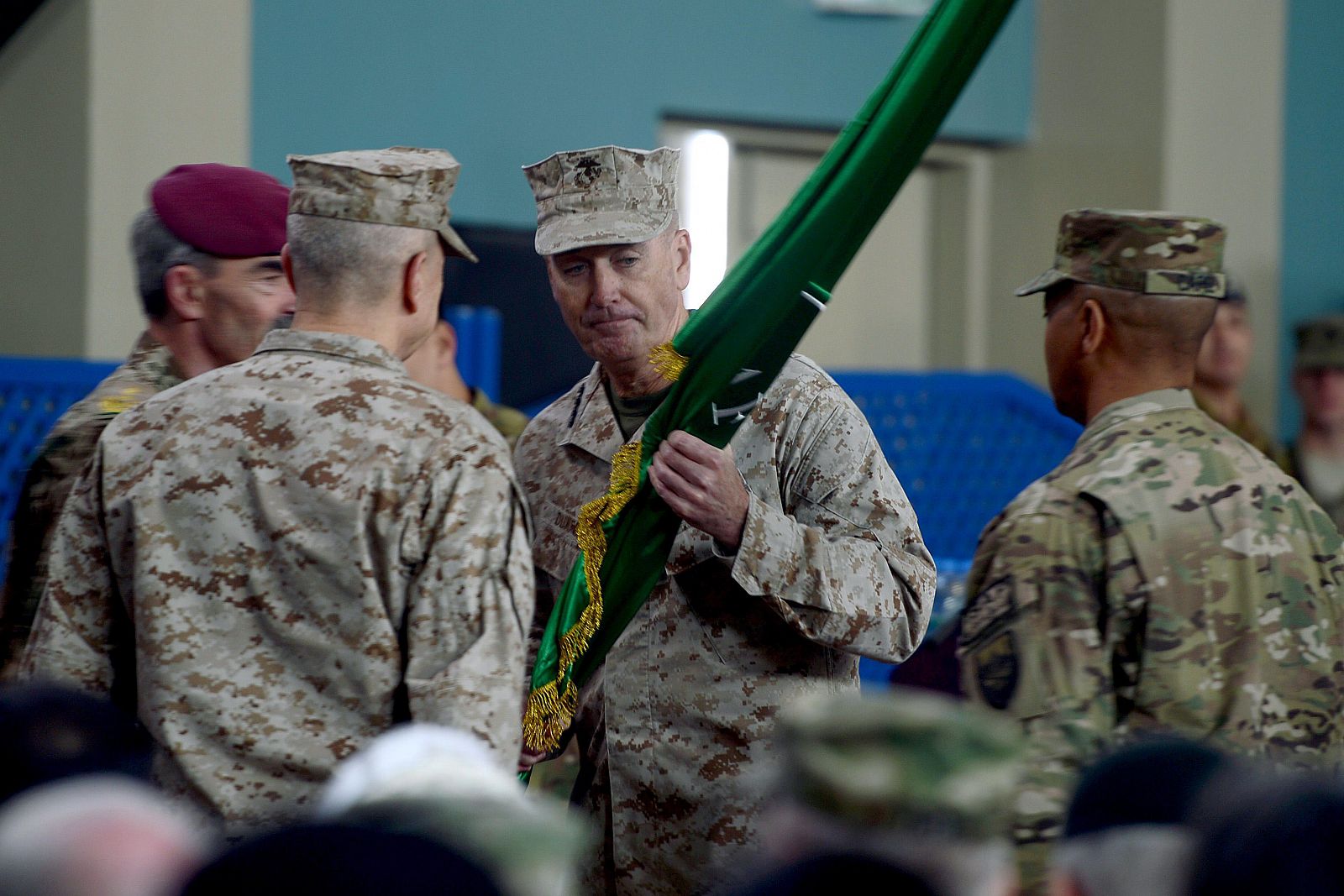 El general Joseph Dunford recibe una bandera durante la ceremonia de traspaso de poderes al mando de la ISAF en Kabul
