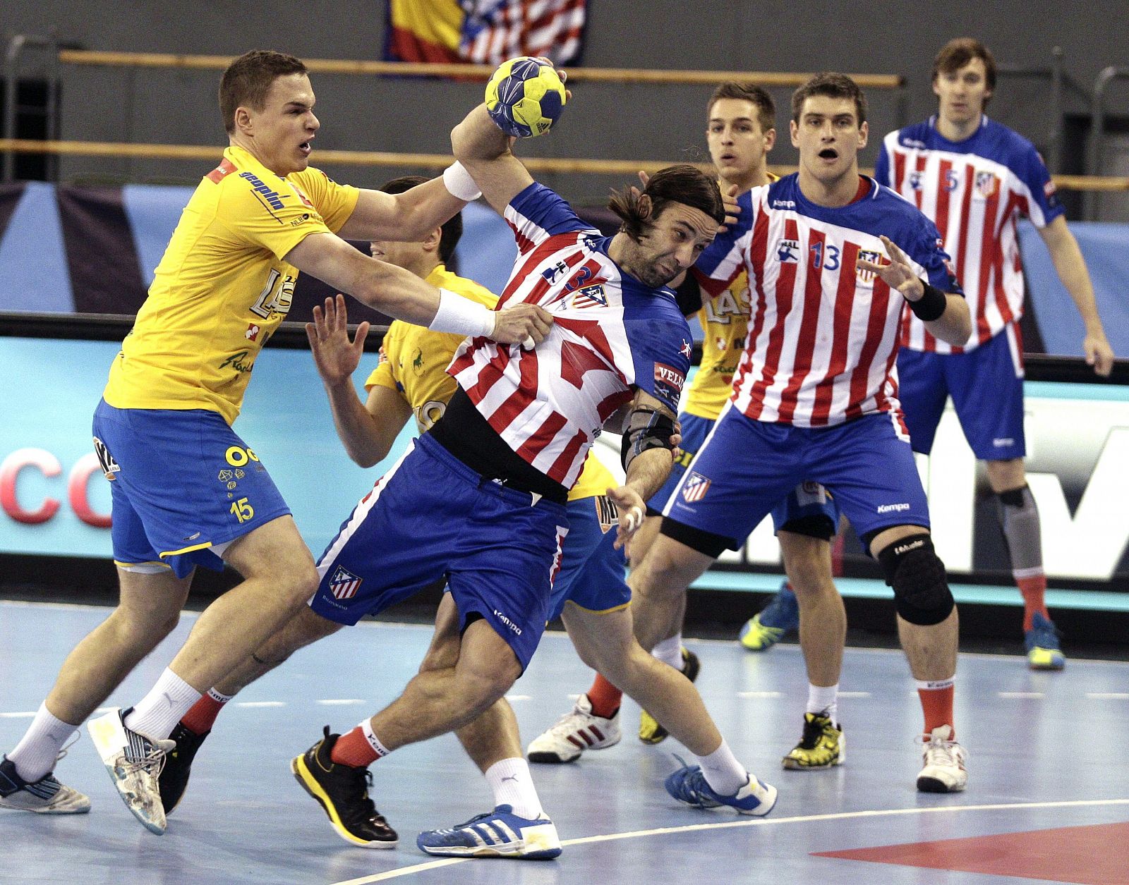 El jugador croata del Atlético de Madrid Ivano Balic (c) intenta lanzar ante la oposición de Vid Poteko (i), del Celje Pivovarna Lasko