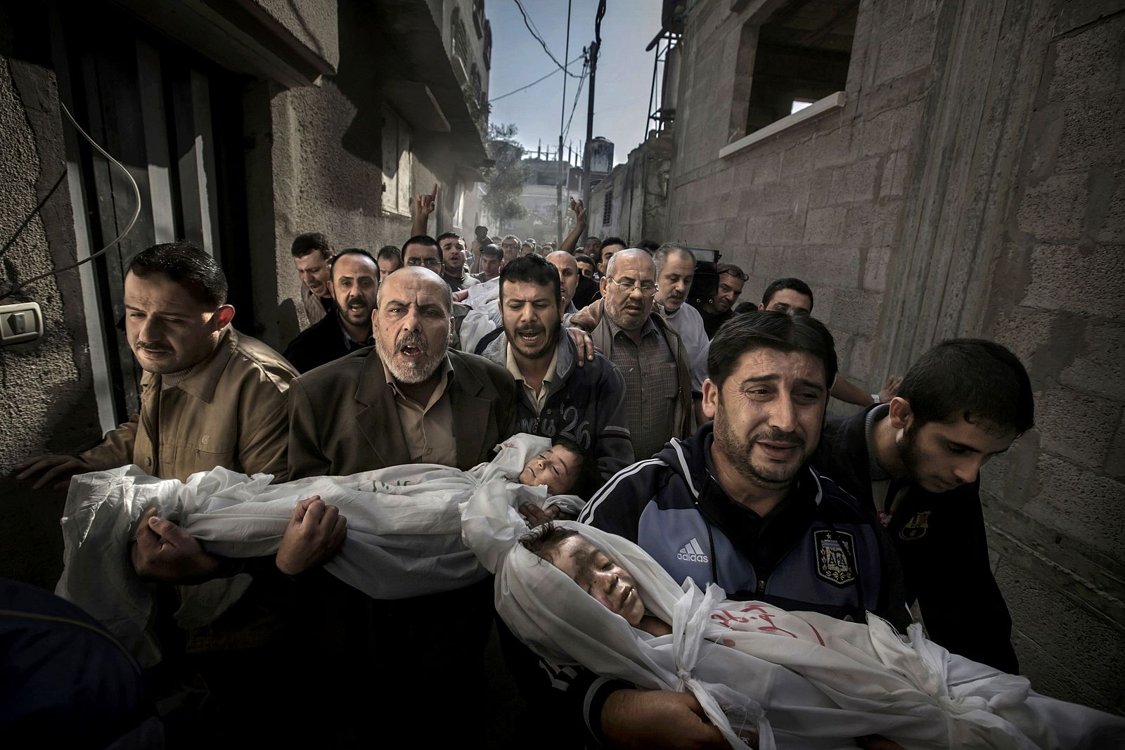Paul Hansen of Sweden has won the World Press Photo of the Year 2012 with this picture of a group of men carrying the bodies of two dead children through a street in Gaza City