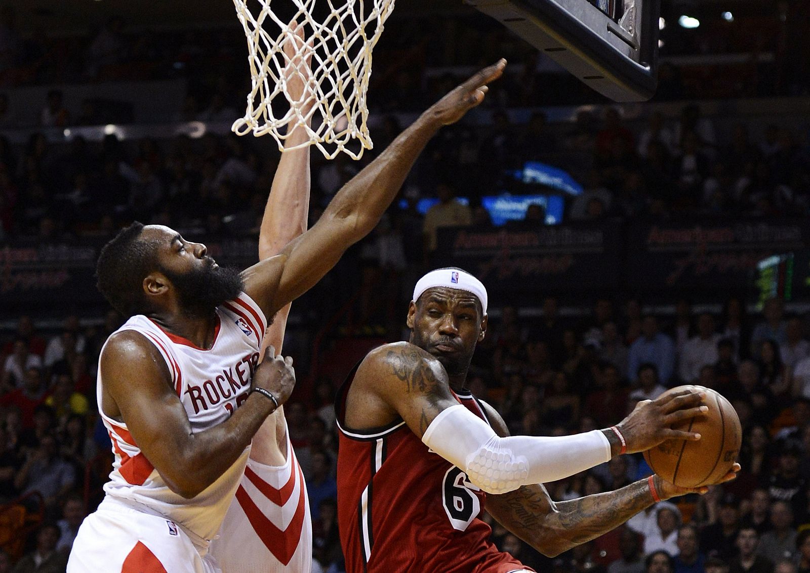 Miami Heat's James is defended by Houston Rockets' Aldrich and Harden during their NBA basketball game in Miami