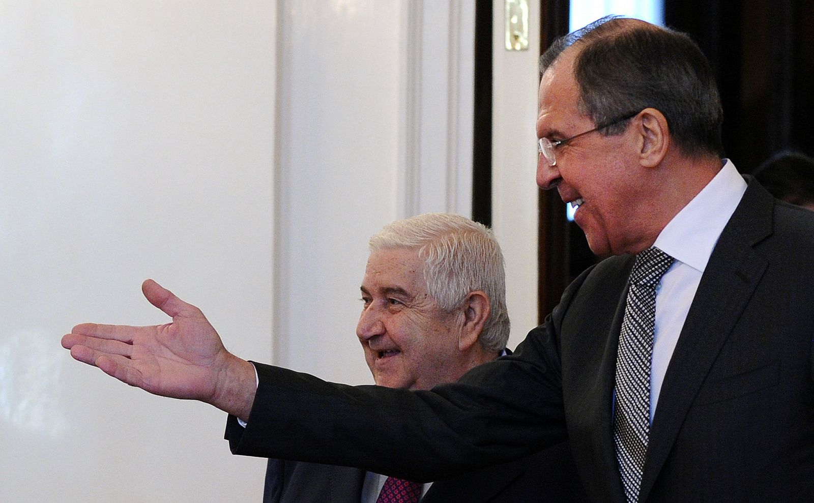 El ministro de Exteriores de Rusia, Sergei Lavrov, franquea el paso a su homólogo sirio Walid al-Muallem.