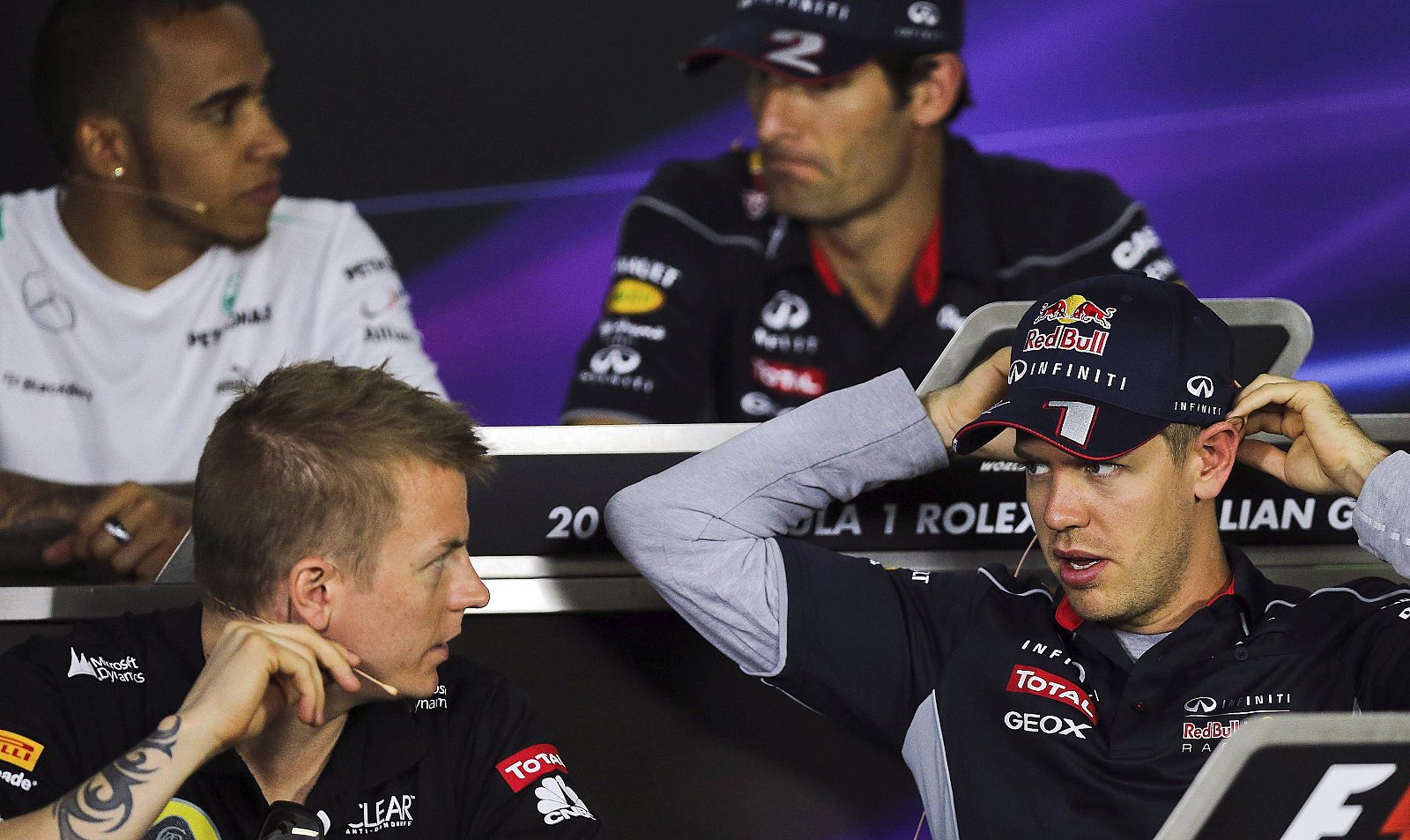 Sebastian Vettel (d), piloto de Red Bull, conversa con Kimi Raikkonen. De fondo, su compañero Mark Webber, junto a Lewis Hamilton