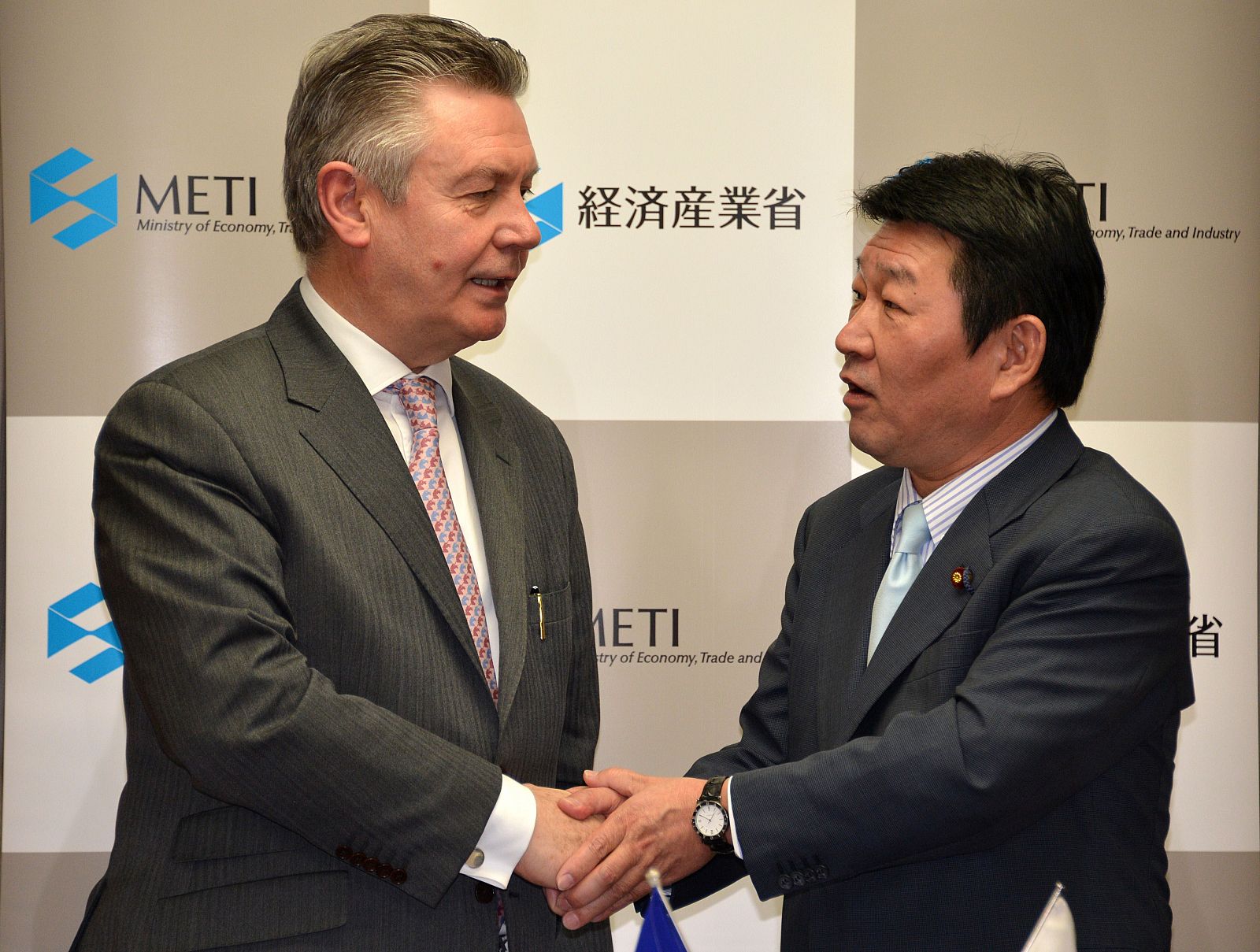 El comisario europeo de comercio, Karel de Gucht y el ministro japonés de Economía, Comercio e Industria, Toshimitsu Motegi, estrechan sus manos tras el acuerdo