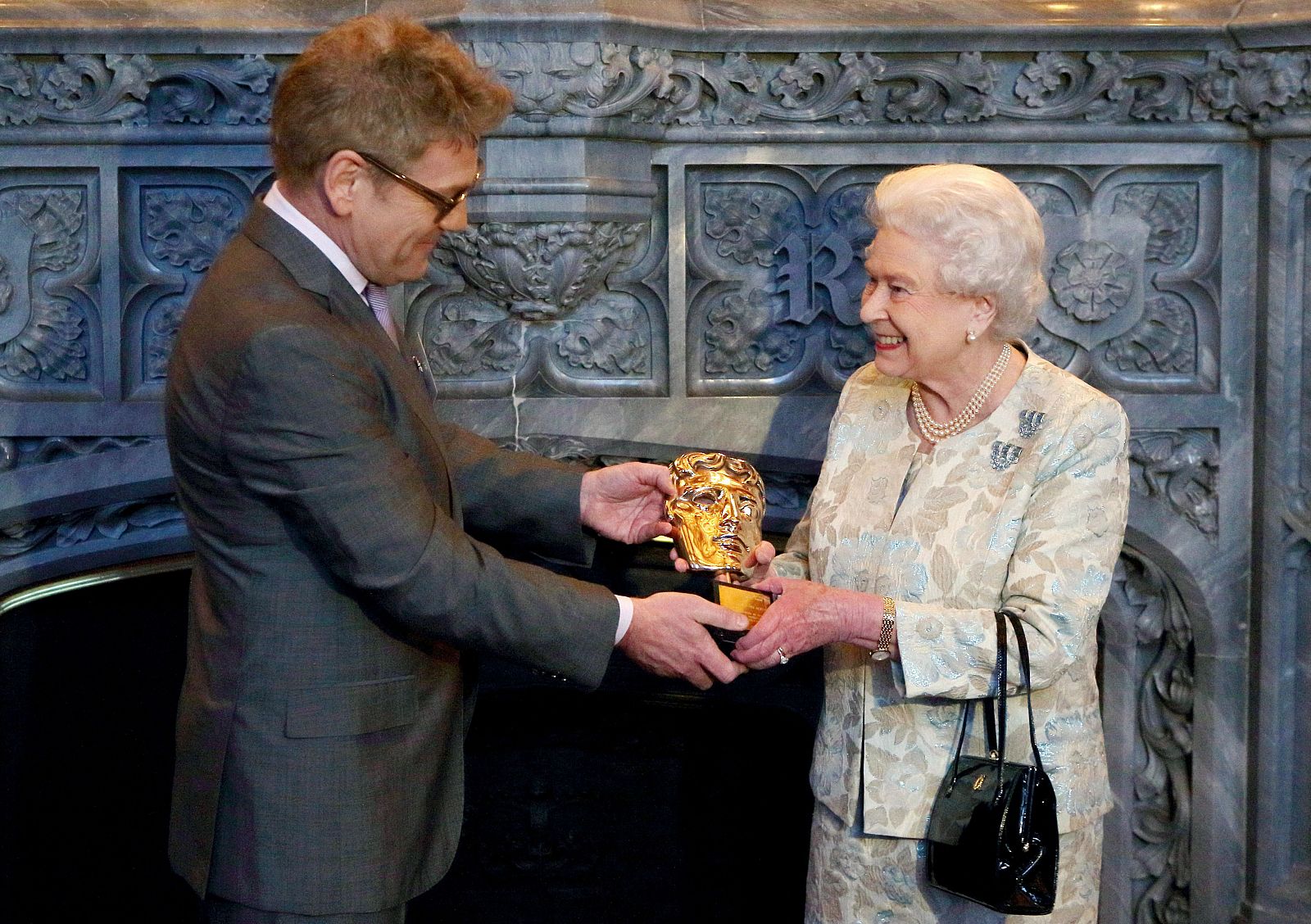 La reina Isabel II recibe el Bafta honorífico de manos del director Kenneth Branagh.