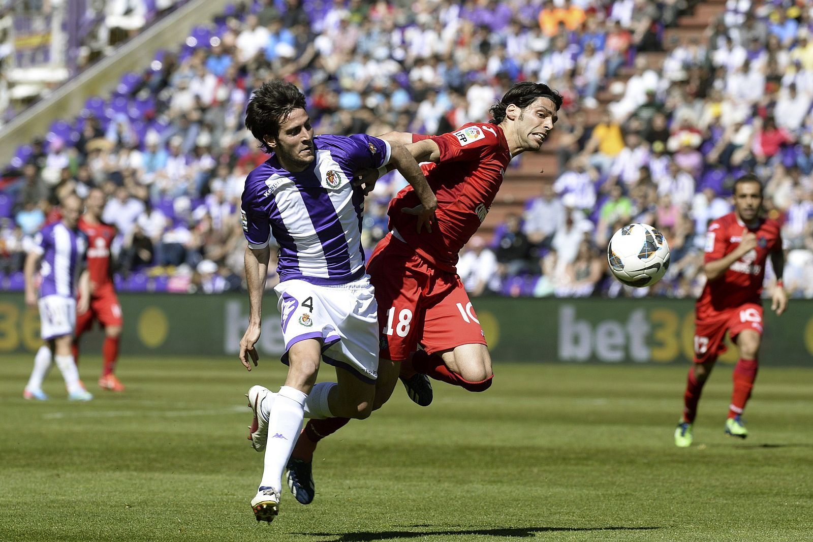 El centrocampista del Getafe Ángel Lafita (d) pugna por el balón con el defensa del Real Valladolid Marc Valiente (i)