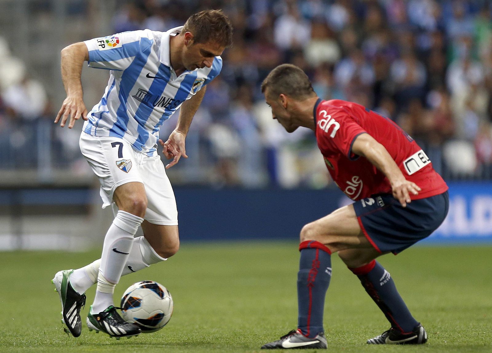 Joaquín Sánchez (i), controla el balón ante Oier Sanjurjo