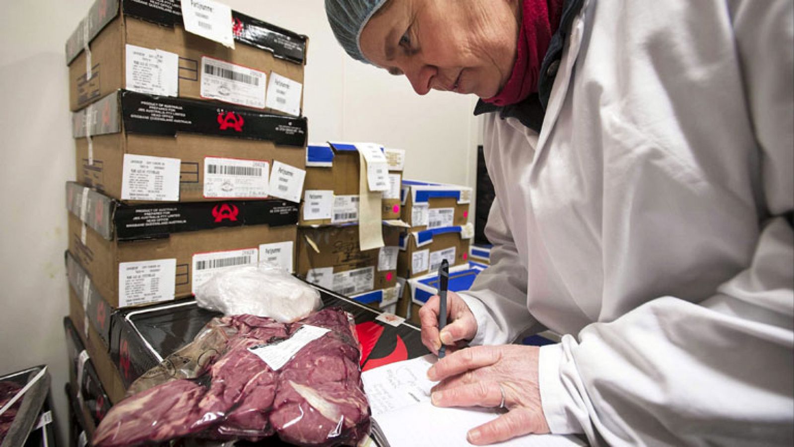 Imagen de archivo de una operaria manipulando carne de vacuno en una fábrica.