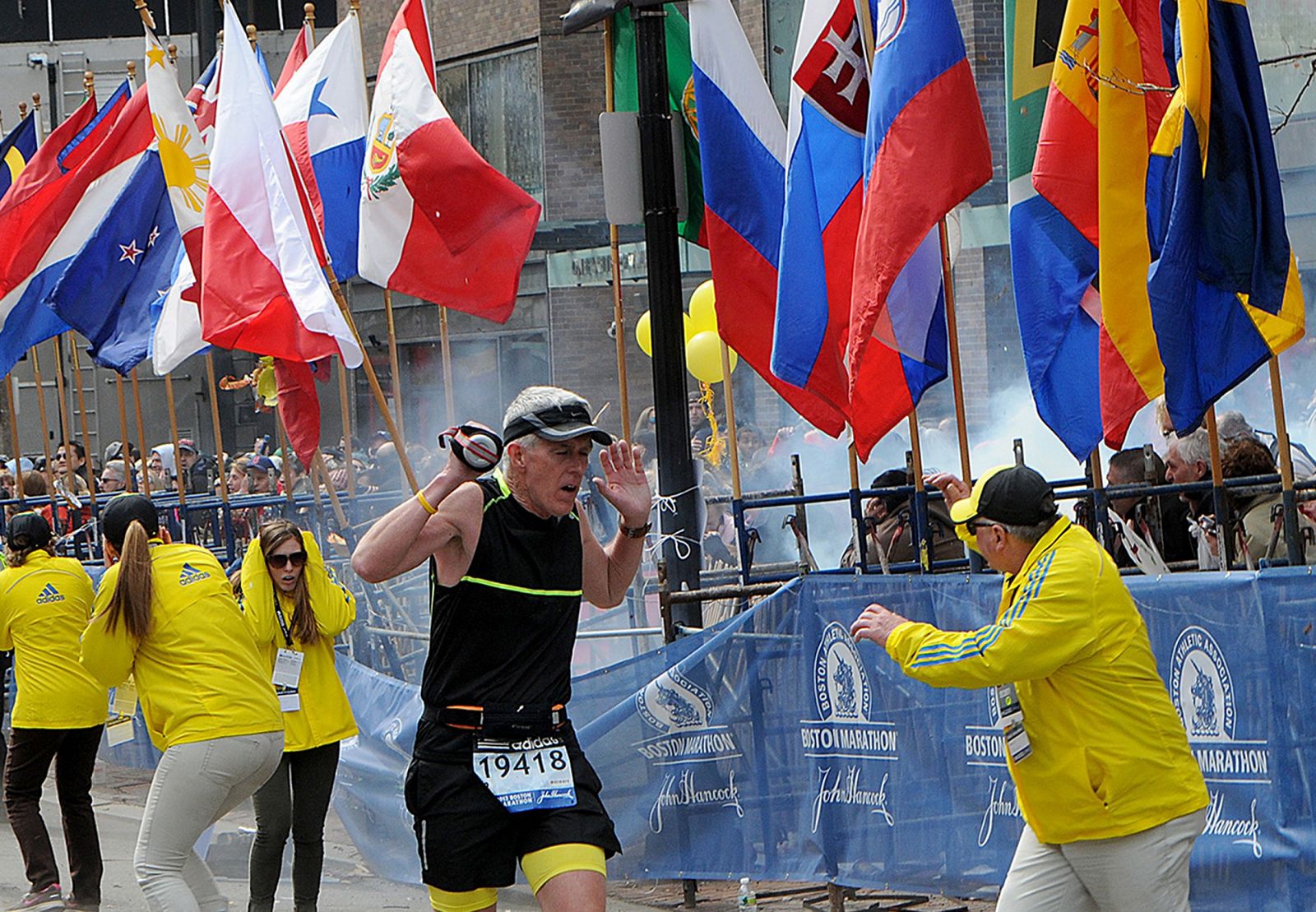 Un corredor y agentes de policía reaccionan a una de las explosiones ocurridas en el maratón de Boston.