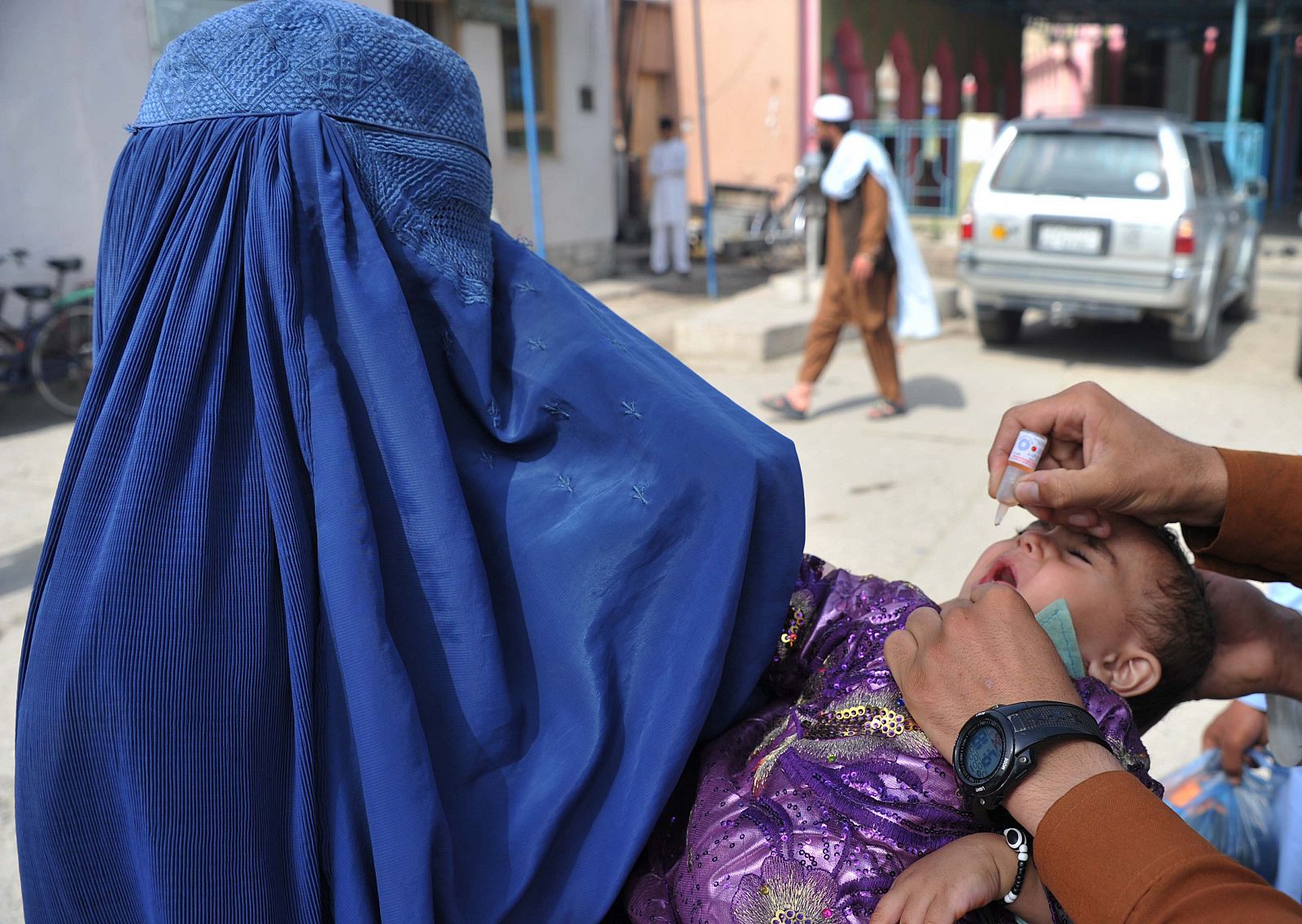 Un empleado sanitario afgano administra la vacuna contra la polio a un niño en Jalalabad