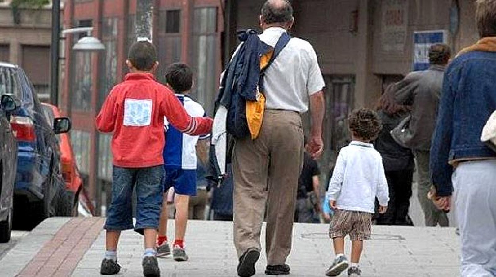 Un abuelo recoge a sus nietos a la salida del colegio
