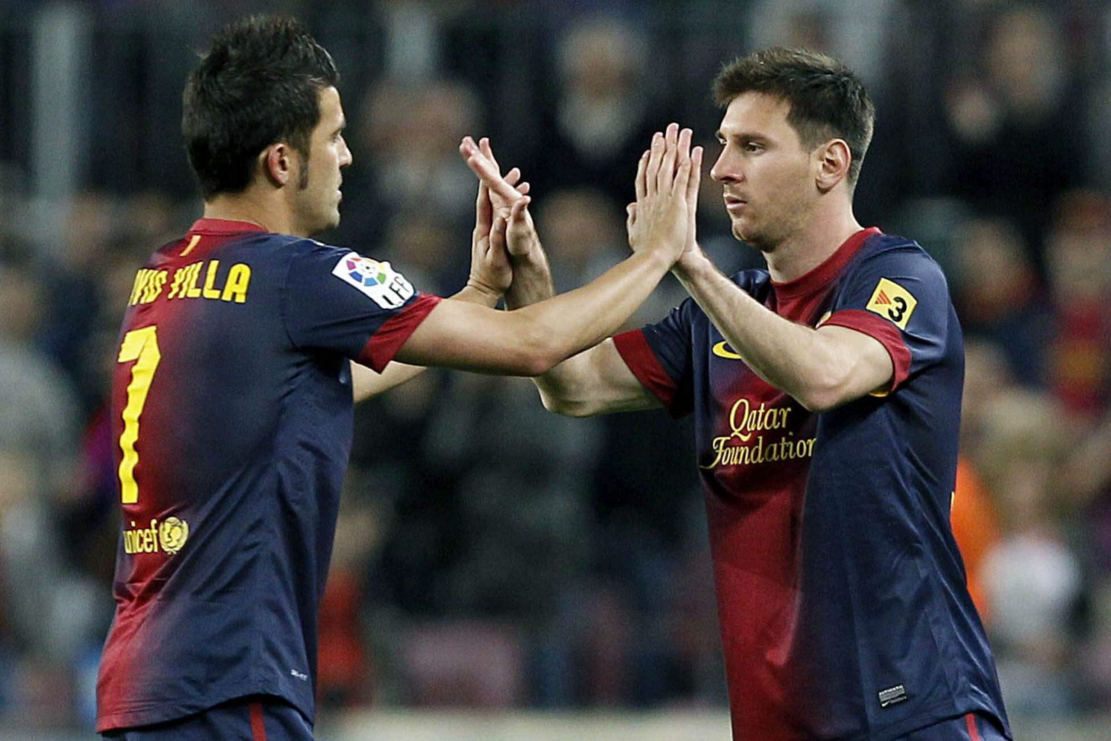 El delantero argentino del FC Barcelona, Leo Messi (d), saluda a su compañero David Villa