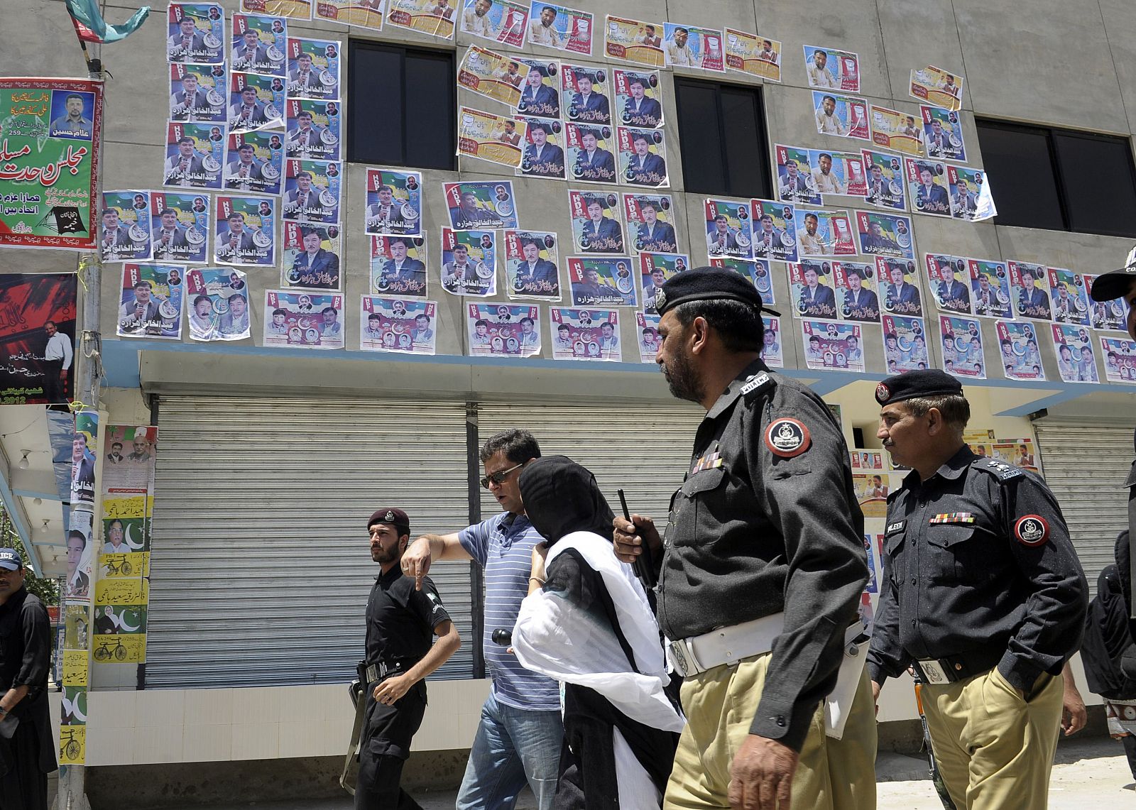 Policías paquistaníes escoltan a periodistas durante un acto de campaña de la minoría chií en Quetta
