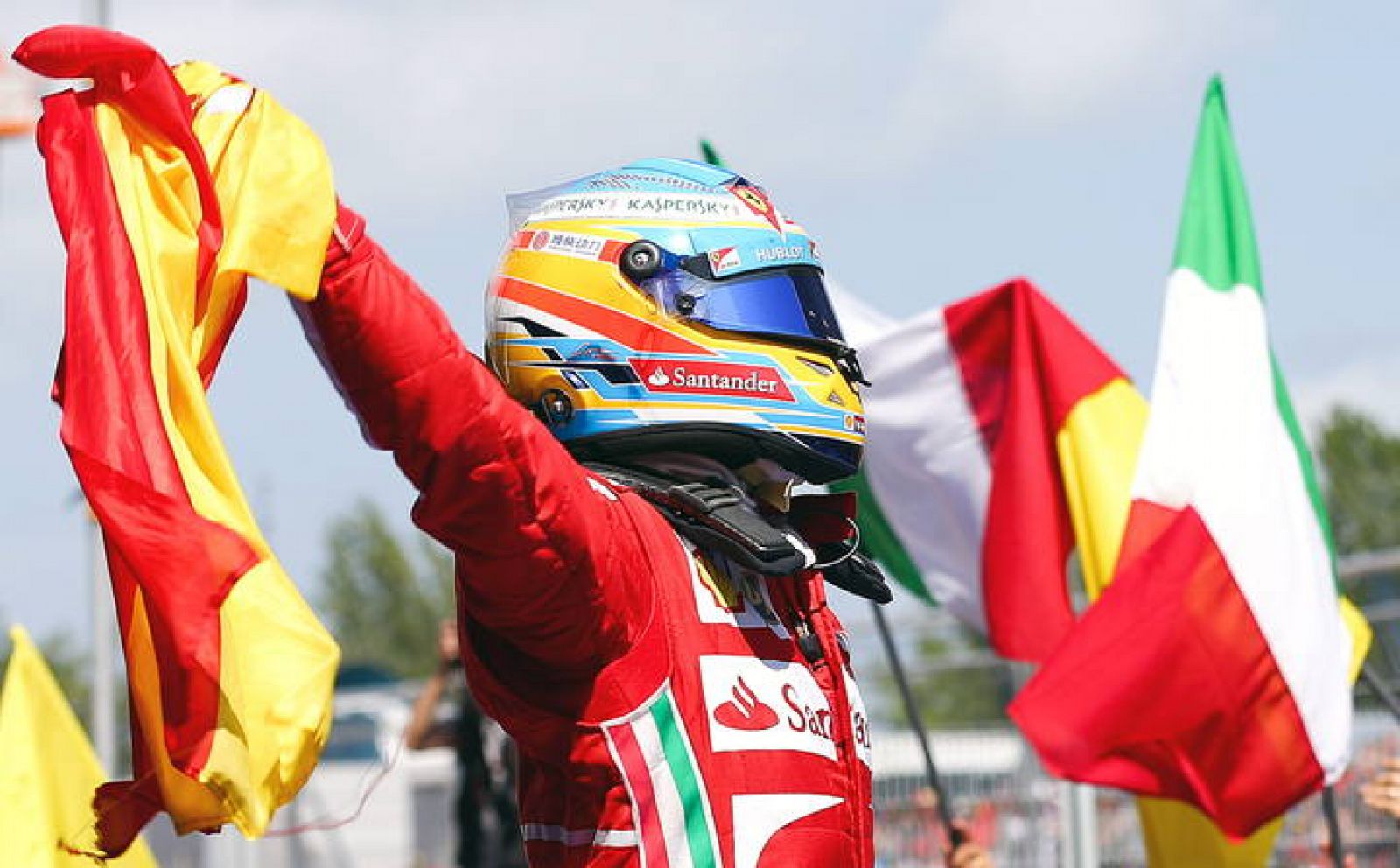 Fernando Alonso celebra con la bandera de España su triunfo.