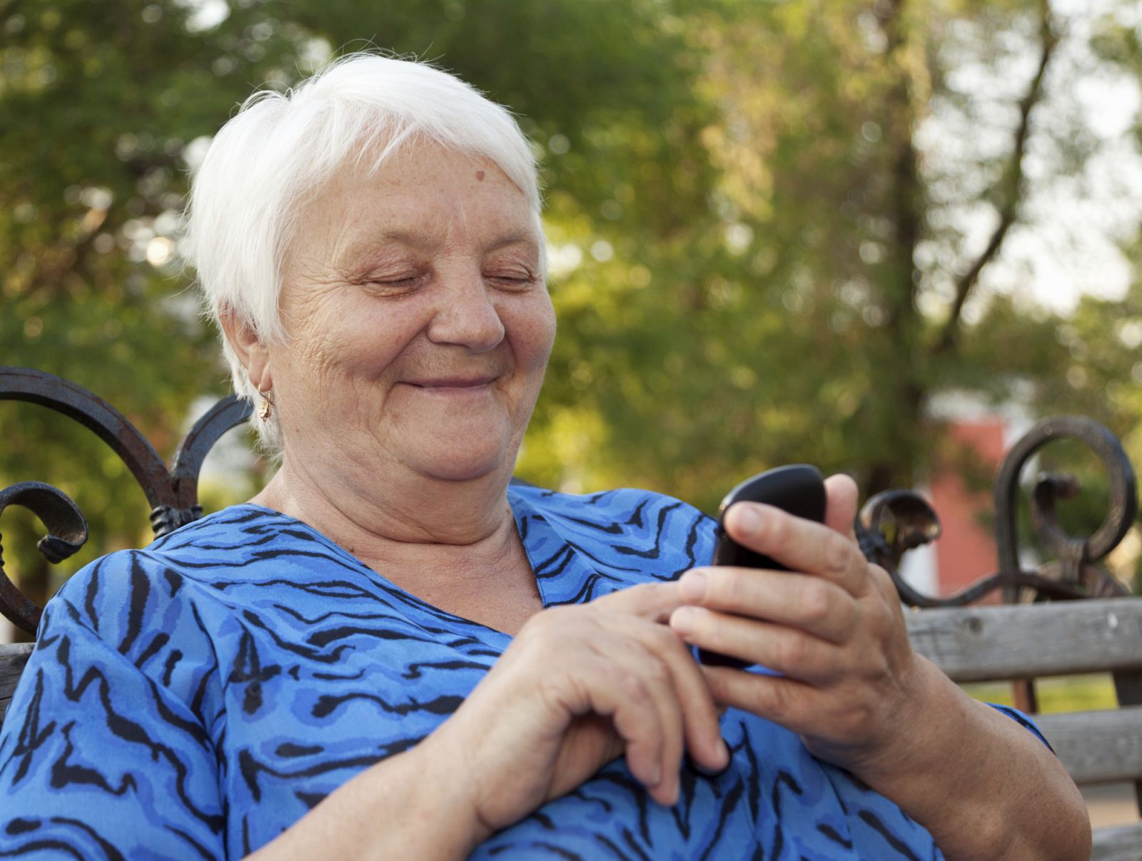 Una mujer mayor usando un teléfono móvil.