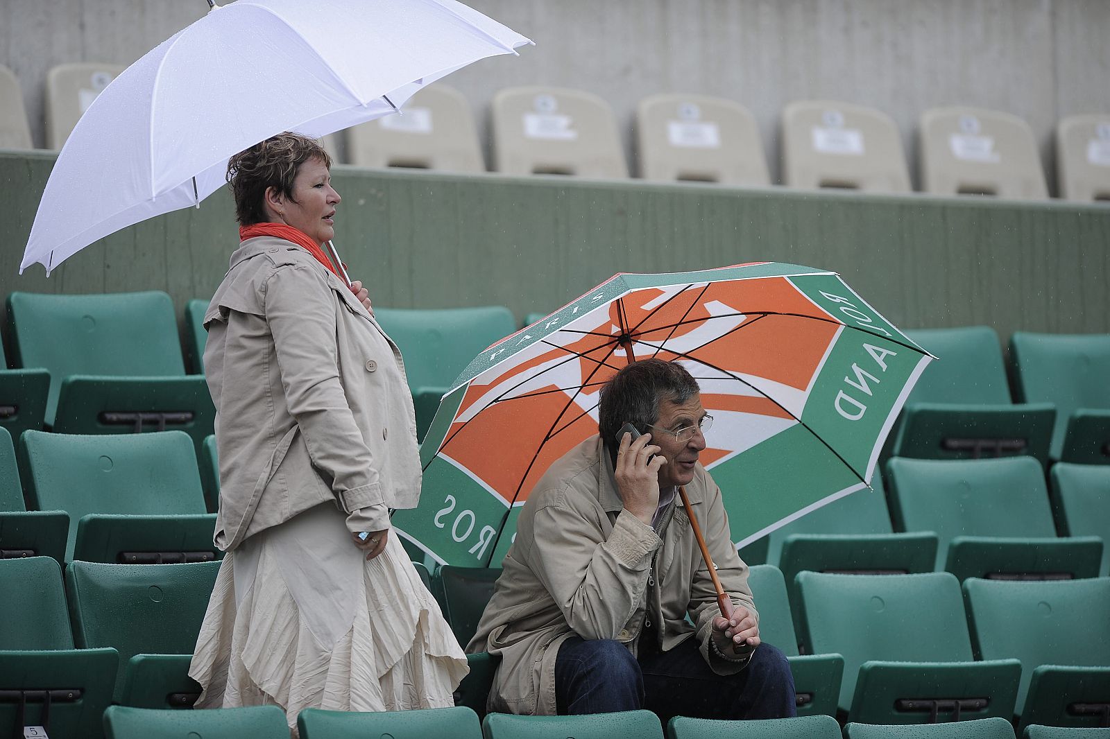 Espectadores se protegen de la lluvia parisina en Roland Garros