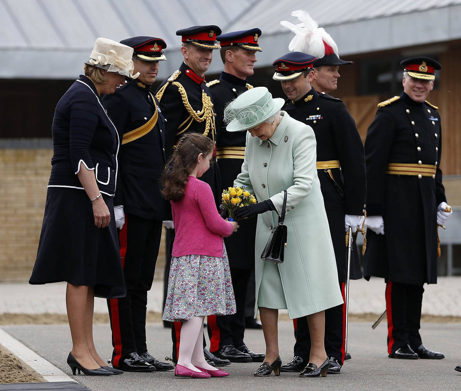 La reina Isabel II recibe flores durante su visita al cuartel de Wookwich, en Londres, donde estaba ubicado el soldado Lee Rigby