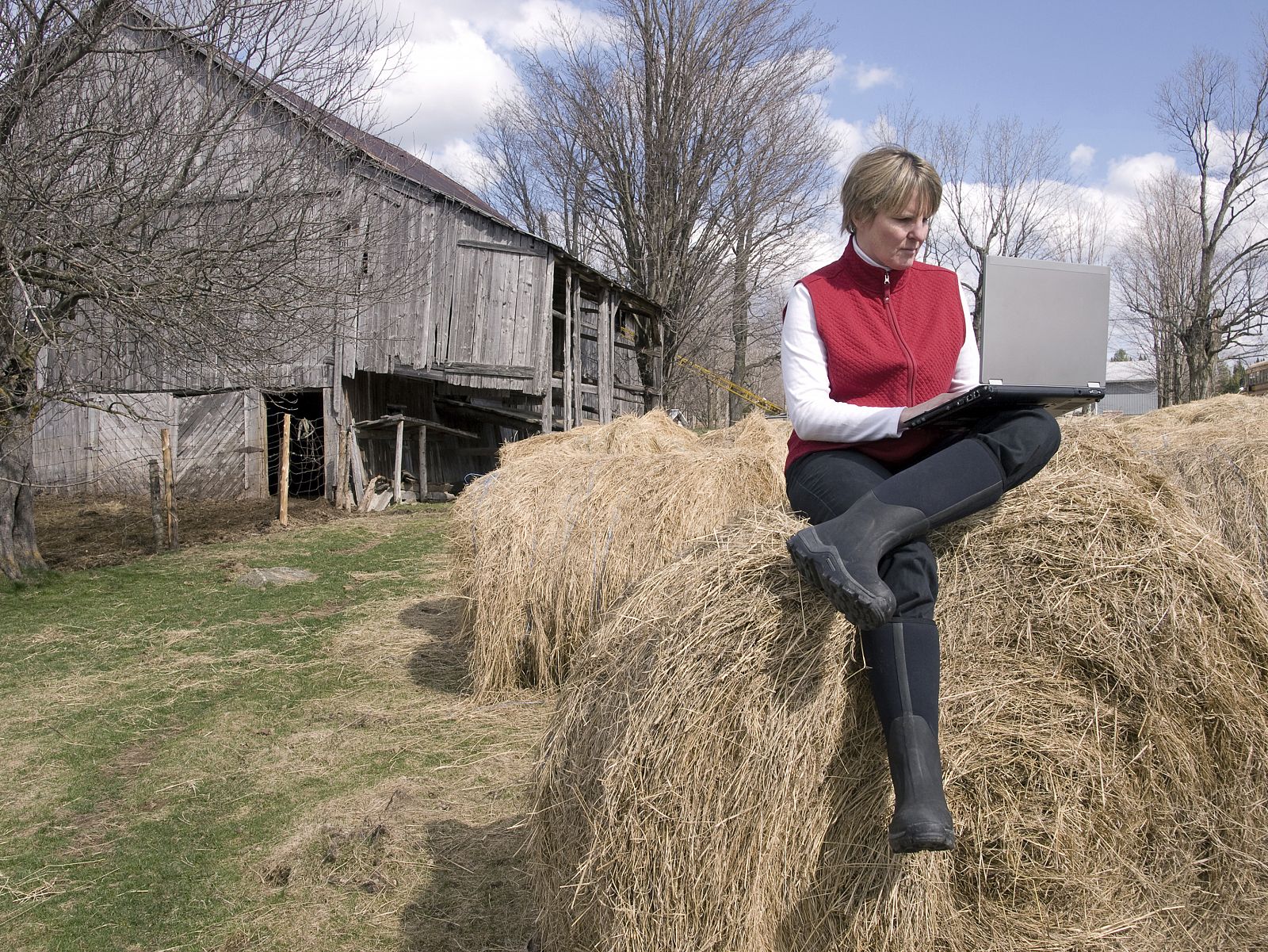 Mujer trabajando con un portátil en una granja.