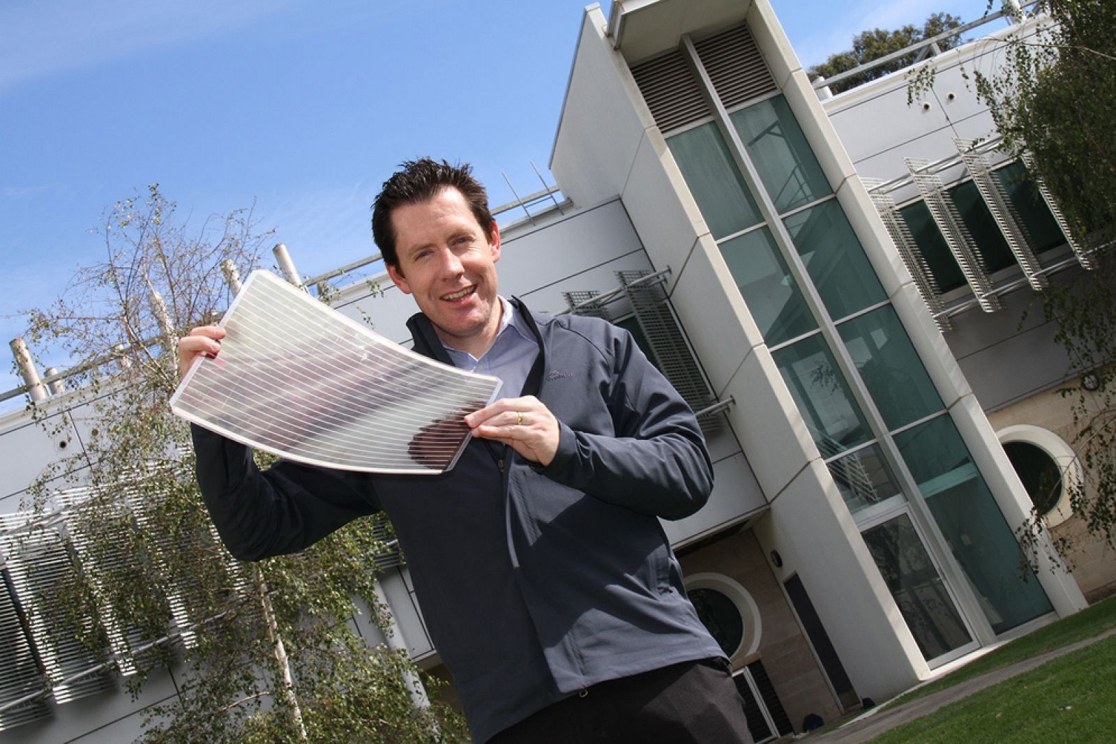 El doctor Scott Walkins con una lámina de paneles solares flexibles.