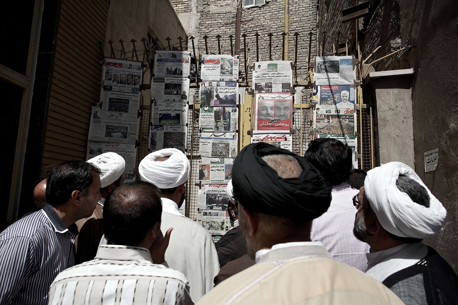 Hombres iraníes miran la prensa en un quiosco de Teherán durante la campaña.