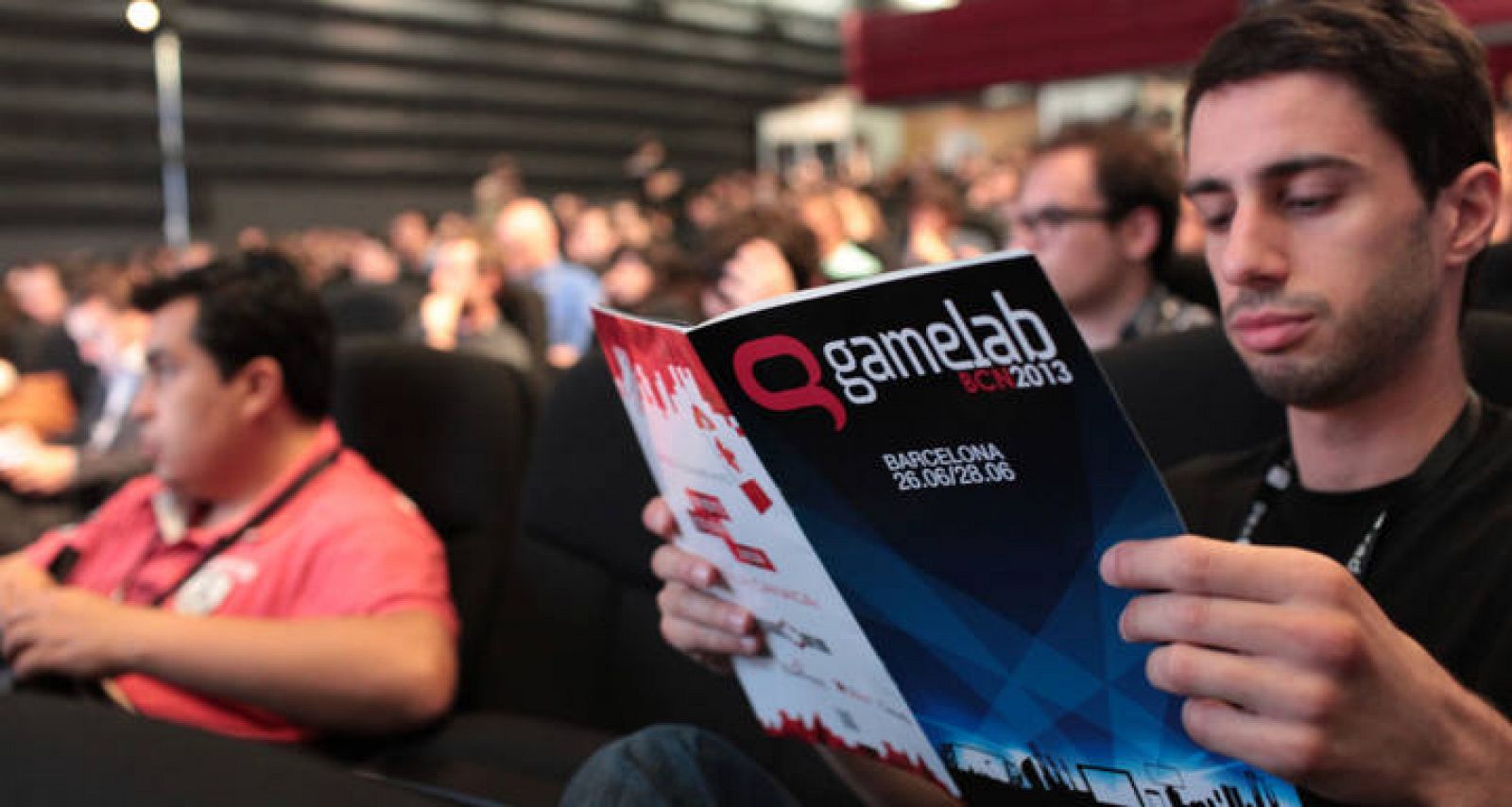 Un asistente ojea el programa de Gamelab 2013.