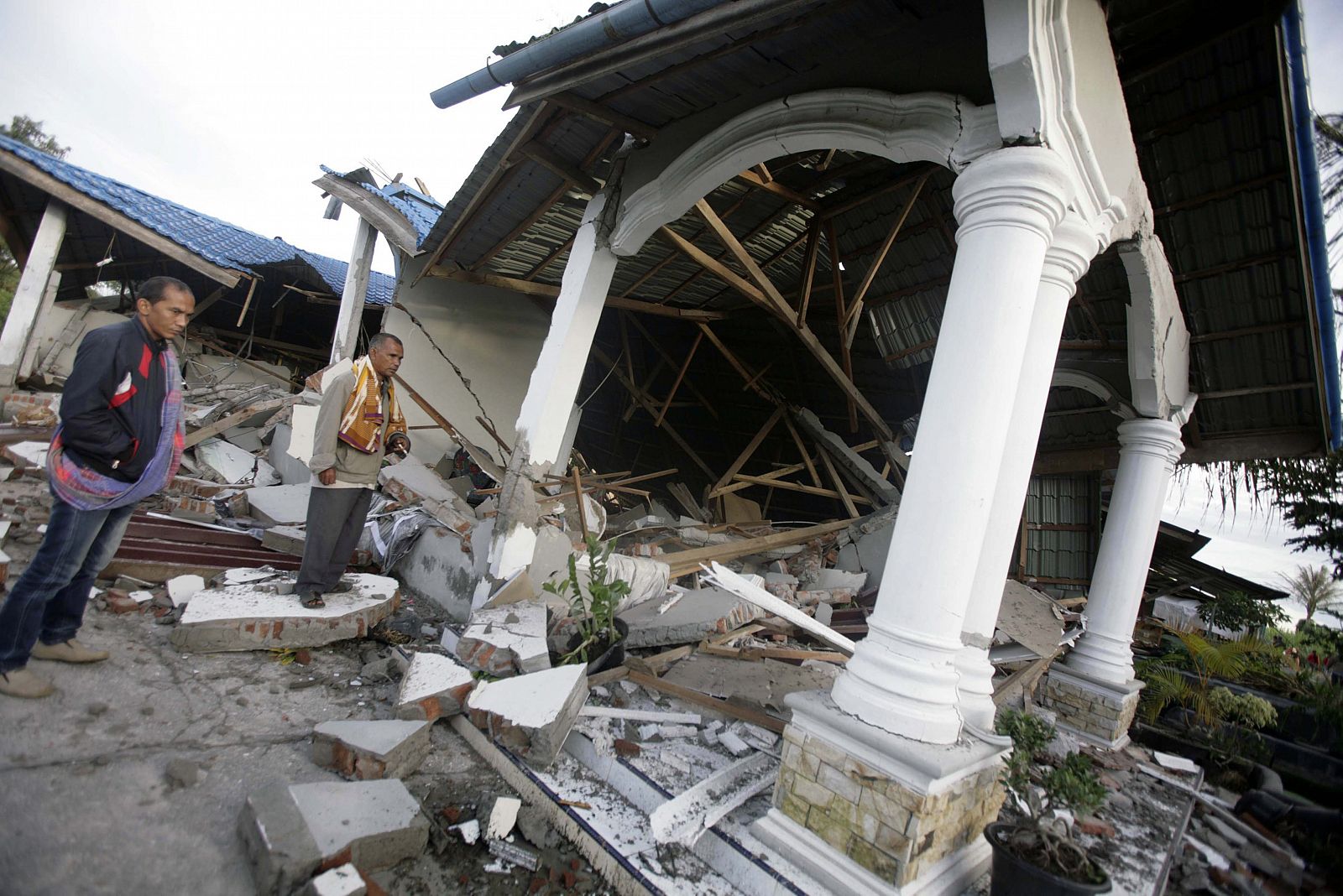 Habitantes examinan una edificación colapsada hoy, miércoles 3 de julio de 2013, en Blang Pancung (Indonesia). Al menos 22 personas murieron y centenares han resultado heridas a causa del terremoto de 6,1 grados de magnitud que sacudió en la jornada