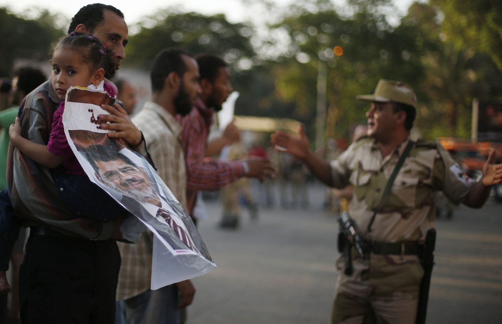 Un manifestante que apoyó el golpe contra Morsi conversa con un miembro del Ejército.