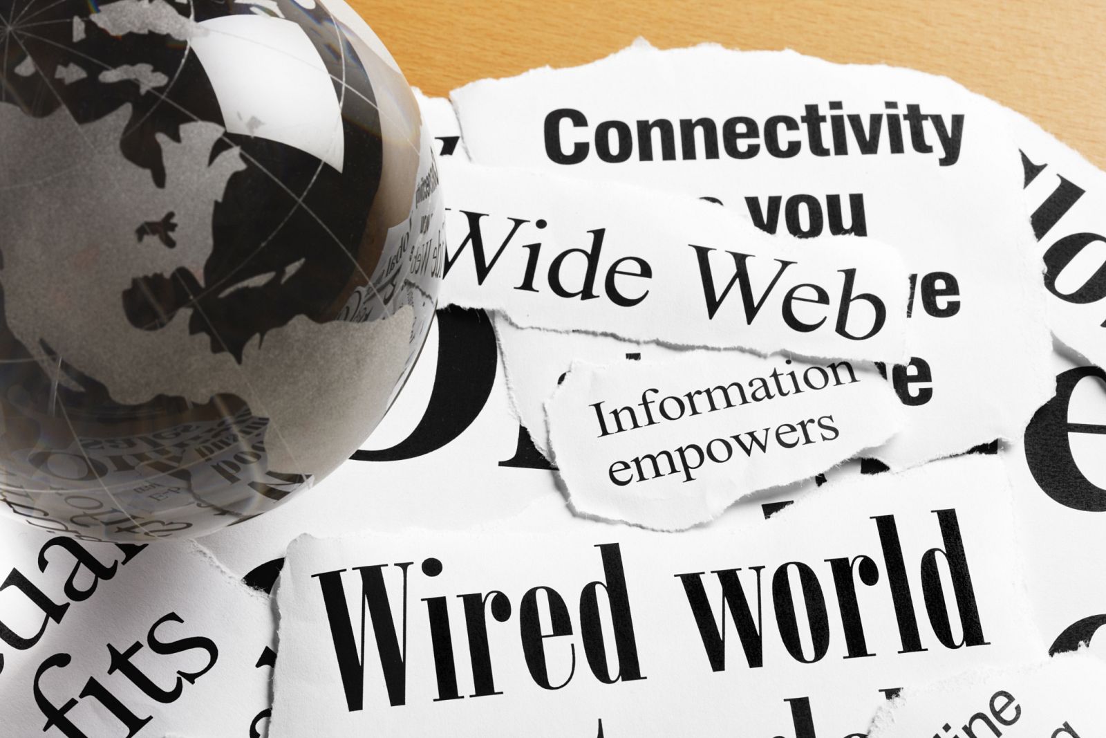 Una bola del mundo con titulares sobre internet y conectividad.