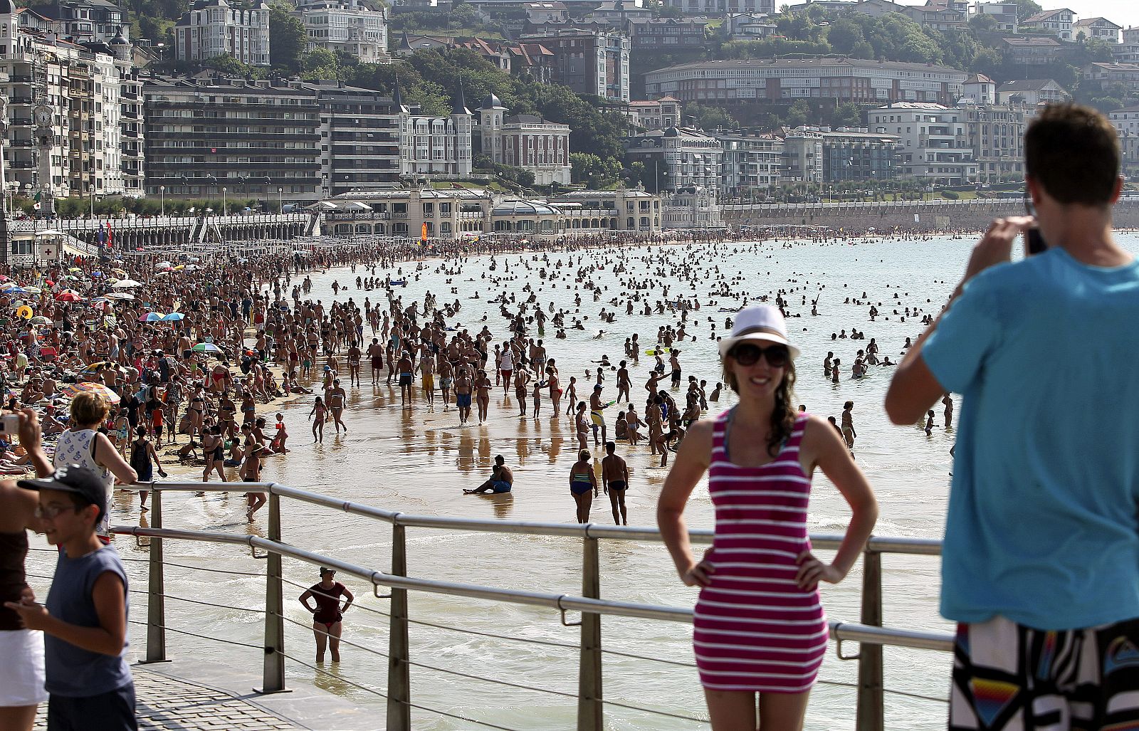 Dos turistas se fotografían junto a la playa de La Concha de San Sebastián