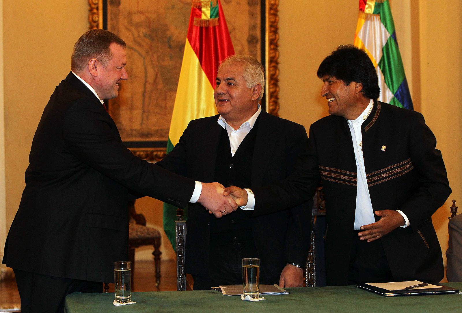 El presidente de Bolivia Evo Morales saluda al vicedirector, gerente y director de operaciones de Gazprom, Roman Kuznetcov, junto al ministro de hidrocarburos y energía, Juan José Sosa
