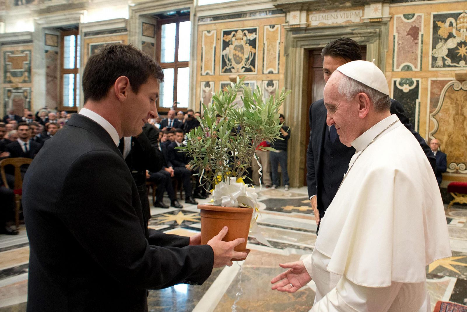 El Papa Francisco (d) recibiendo un árbol de olivo de manos de Lionel Messi (i).