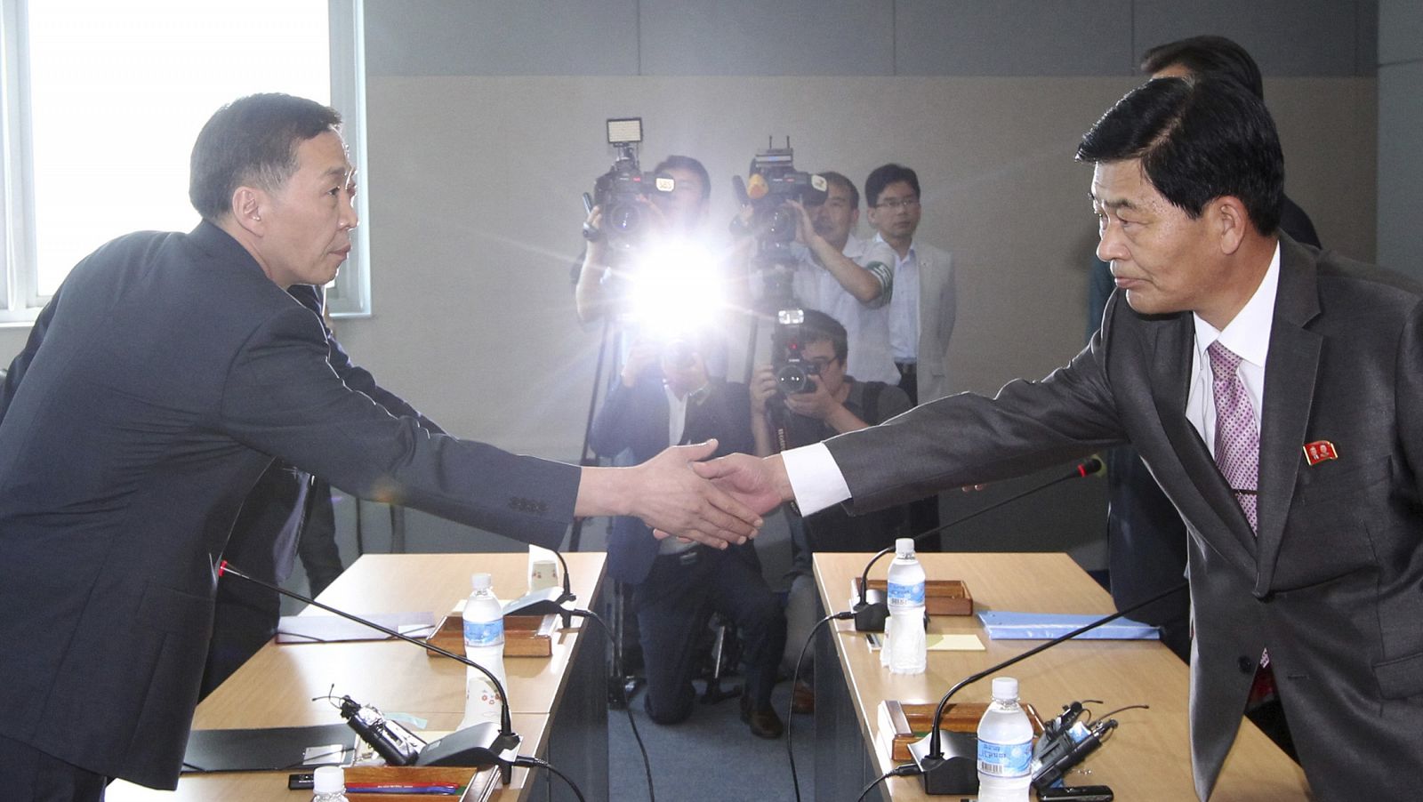 El representante de Corea del Sur, Kim Ki-woong, y el de Corea del Norte, Park Chol-su, cierran con un apretón de manos el acuerdo para reabrir Kaesong.
