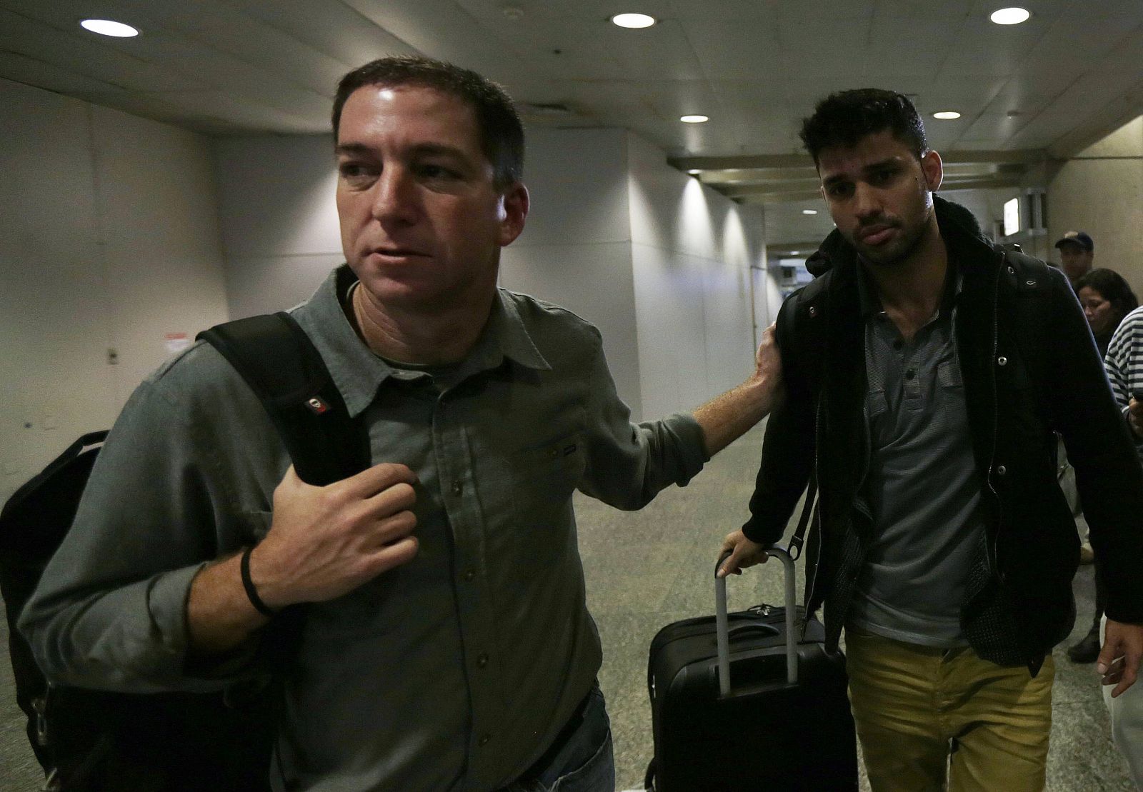 El periodista estadounidense Glenn Greenwald camina junto a su pareja, David Miranda, a su llegada al Aeropuerto Internacional de Río de Janeiro (Archivo).