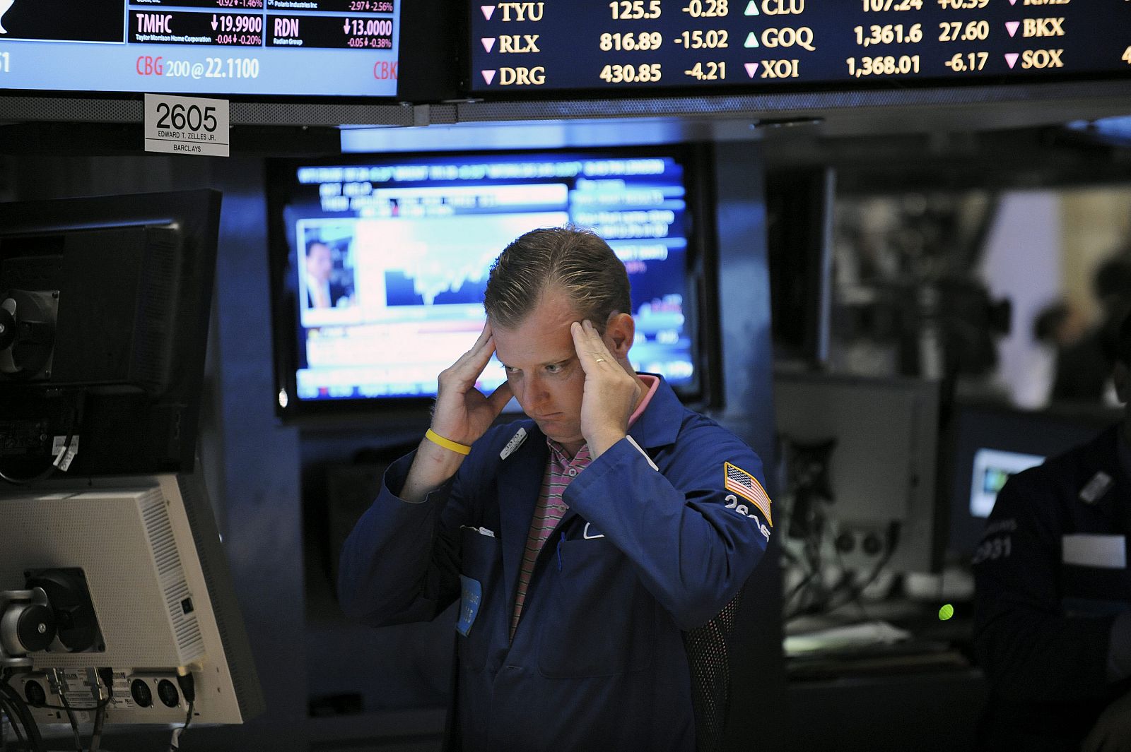 Un trabajador de la Bolsa de Wall Street observa la tendencia de las acciones en pantalla