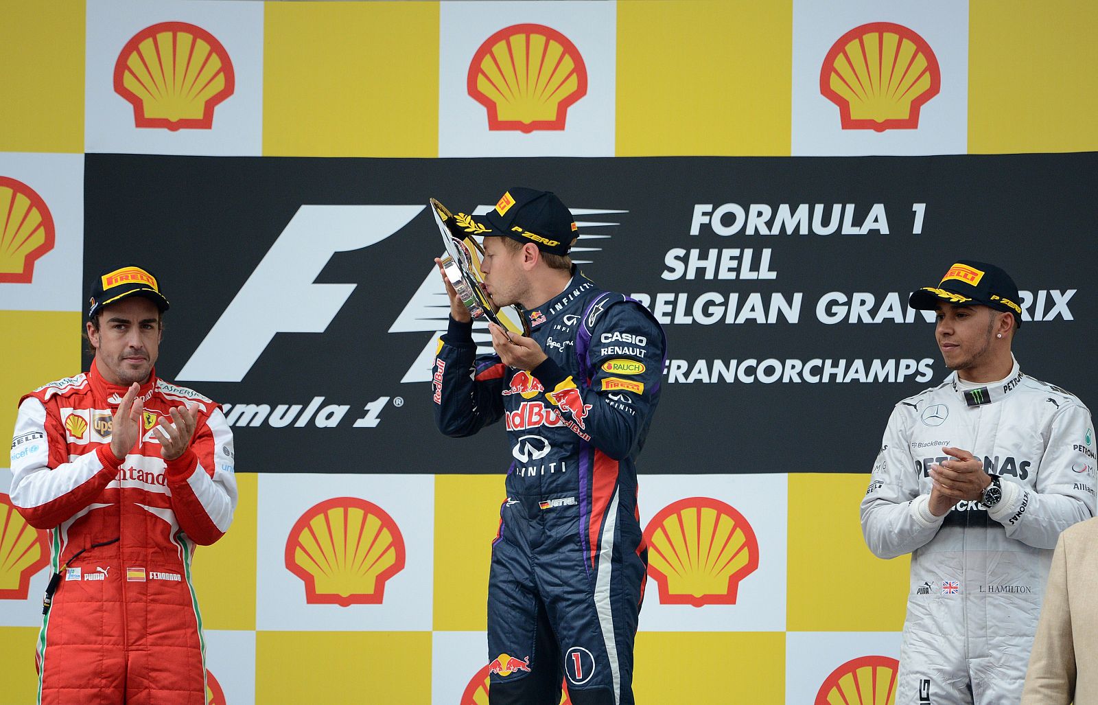 Sebastian Vettel celebra su victoria escoltado por Alonso y Hamilton en el podio de Spa.