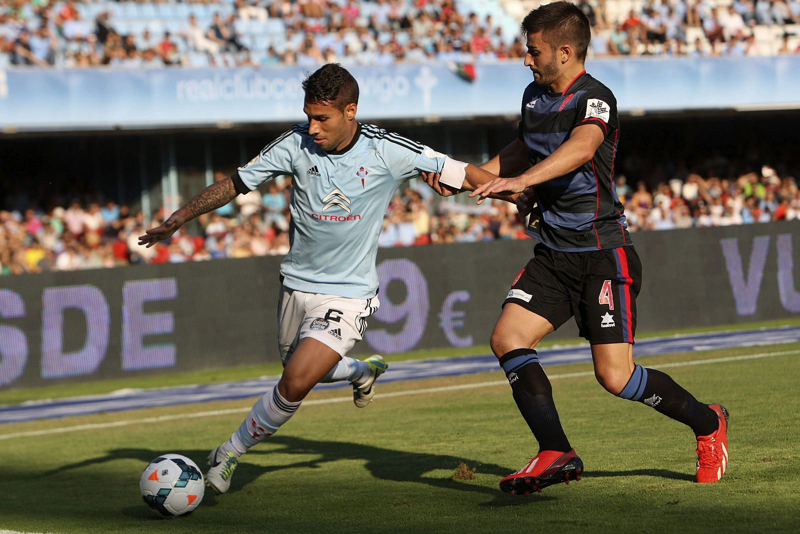 El defensa del Celta de Vigo Hugo Mallo (i) pelea un balón con el centrocampista del Granada Fran Rico