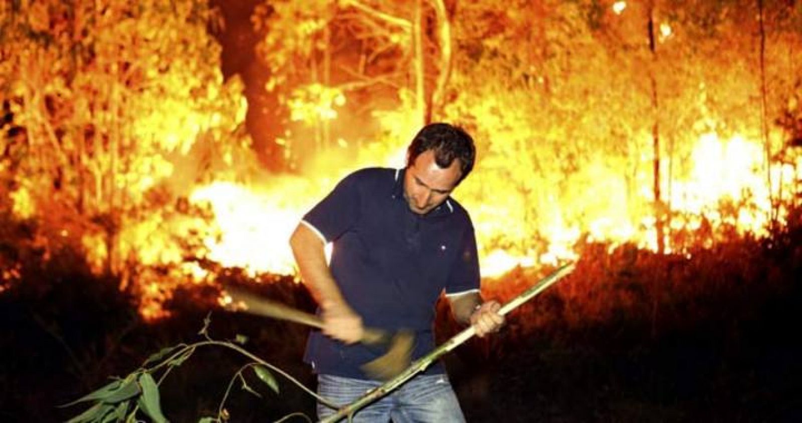 Un vecino de Barbudo prepara una rama para ayudar a atajar el incendio que se ha originado, con varios focos sobre las 8 de la tarde de este miércoles, junto a la aldea de Barbudo, en el municipio de Ponte Caldelas, provincia de Pontevedra