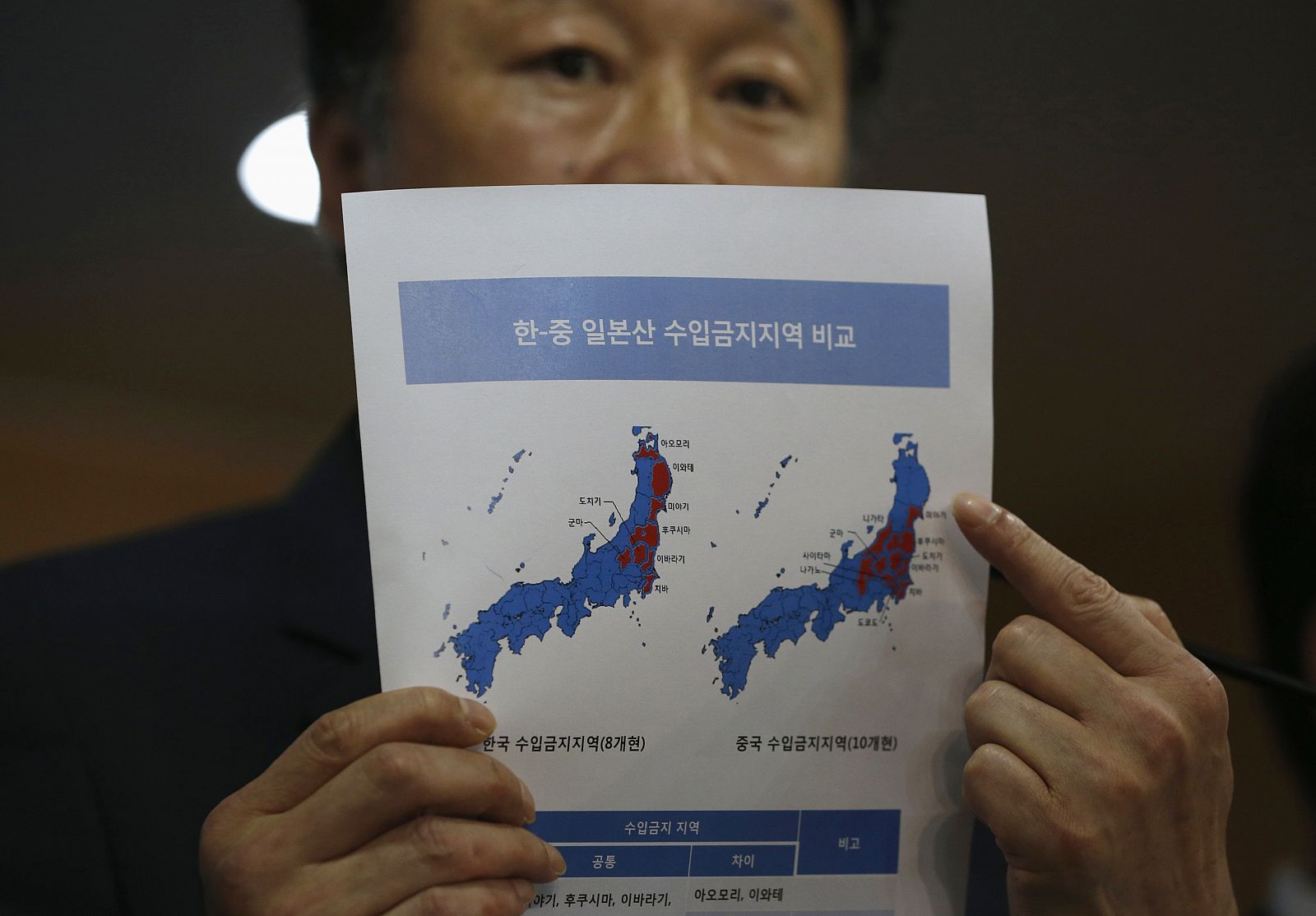 El viceministro surcoreano de Asuntos Marítimos y Pesca, Son Jae-hak, muestra en un documento las prefecturas japonesas de las zonas prohibiciones de importación (en rojo) impuestas por Corea del Sur y China, respectivamente.