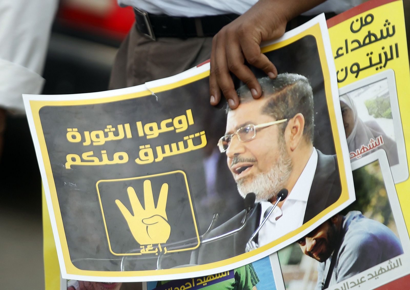 Un partidario de los Hermanos Musulmanes sostiene una pancarta de Morsi.
