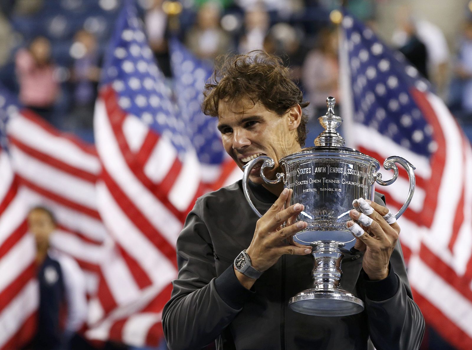 Rafael Nadal celebra su título en el US Open 2013 con su tradicional gesto de morder el trofeo