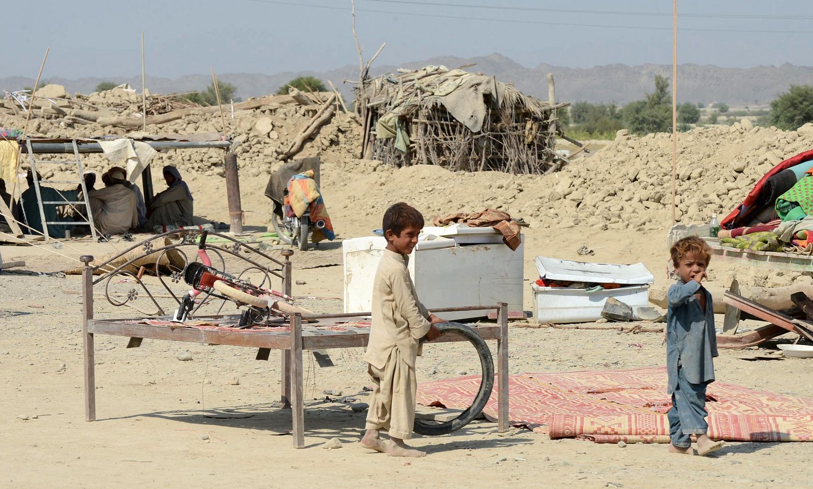 Supervivientes del terremoto de Baluchistán juegan cerca de casas derrumbadas en la zona de Dhall Bedi Peerander.