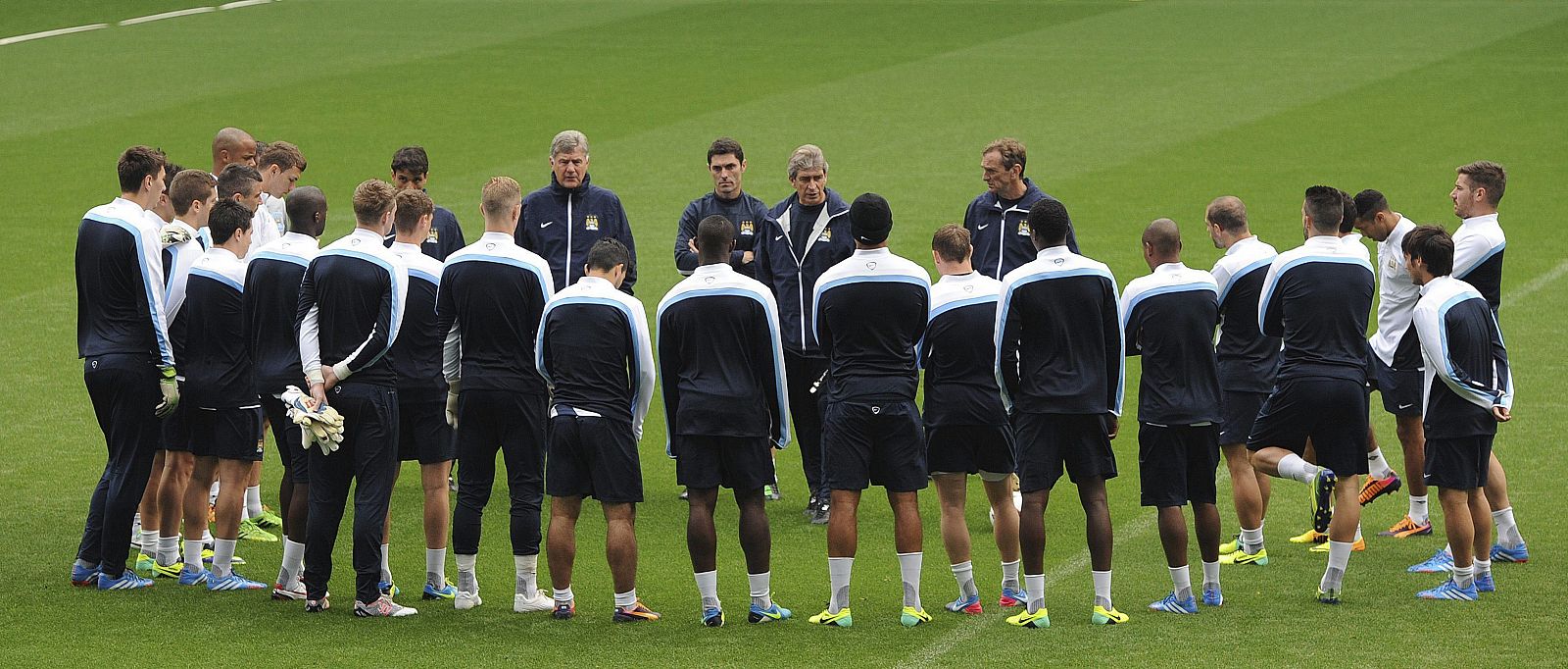 Los jugadores del del Manchester City escuchan las órdenes de su entrenador, Manuel Pellegrini