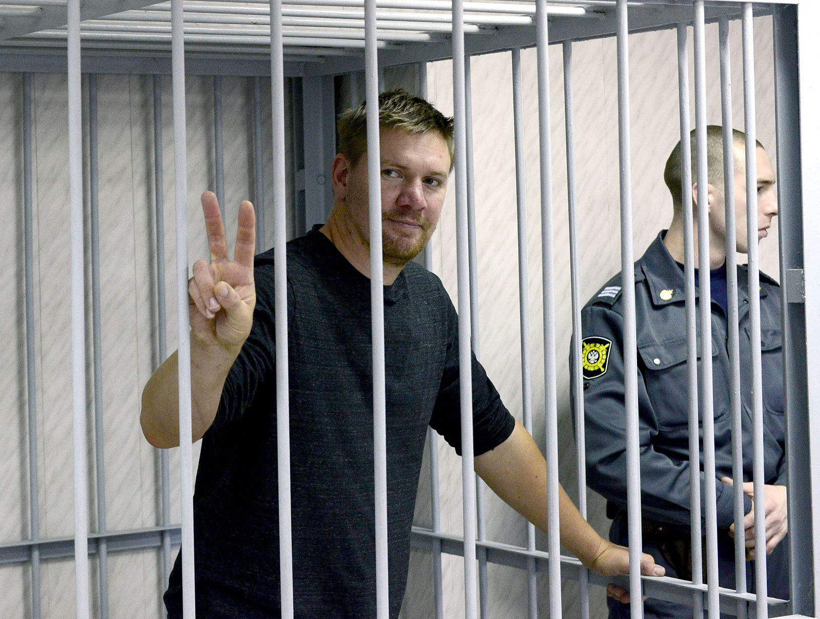 El activista de Greenpeace Anthony Perrett hace la señal de la victoria en el tribunal de Mumrmansk, Rusia